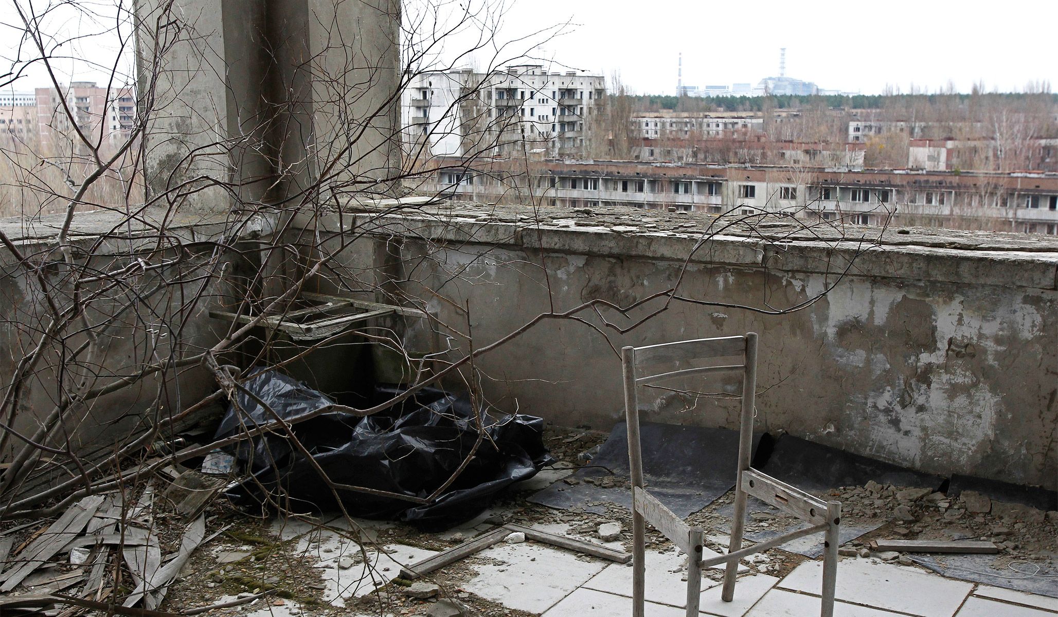 The sarcophagus covering the damaged fourth reactor at the Chernobyl nuclear power plant visible in the distance seen from the balcony of a building in the abandoned city of Pripyat, April 4, 2011.