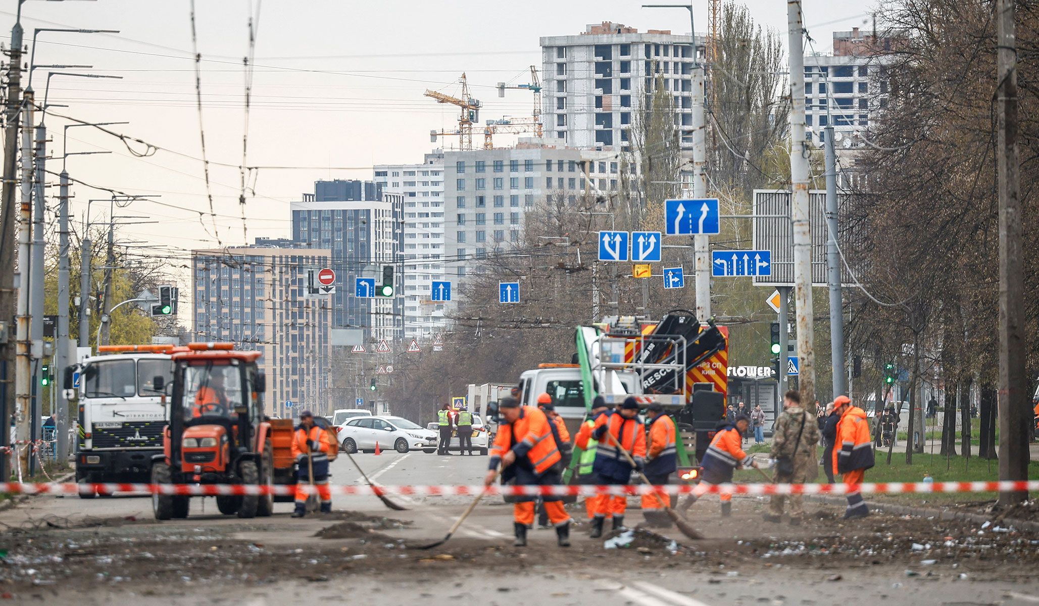 Workers clean up a street near damaged apartment buildings at the site of a Russian missile strike in Kyiv, Ukraine, April 16, 2026.