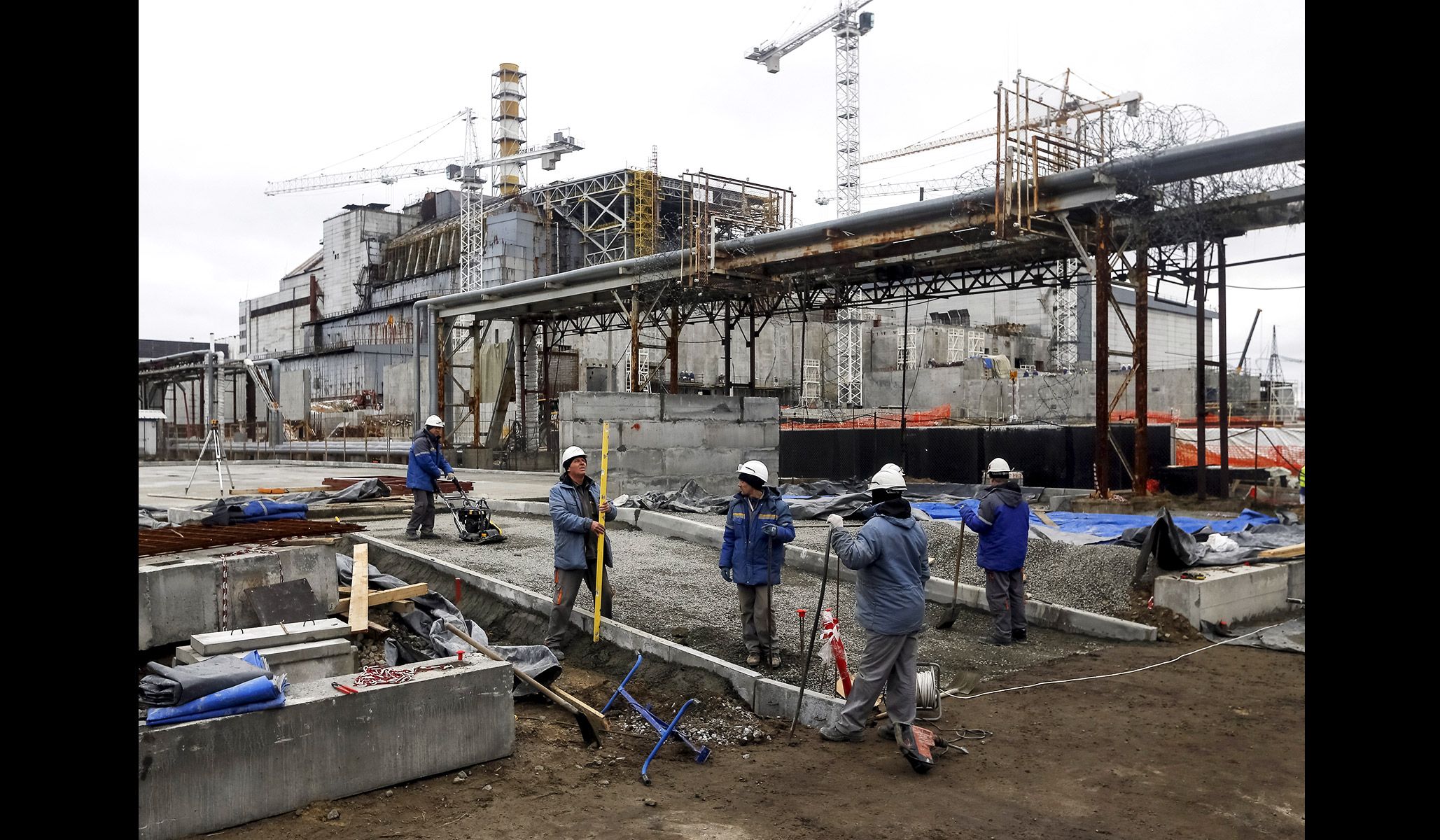 Employees work in front of the sarcophagus covering the damaged fourth reactor at the Chernobyl nuclear power plant in Ukraine, March 23, 2016.