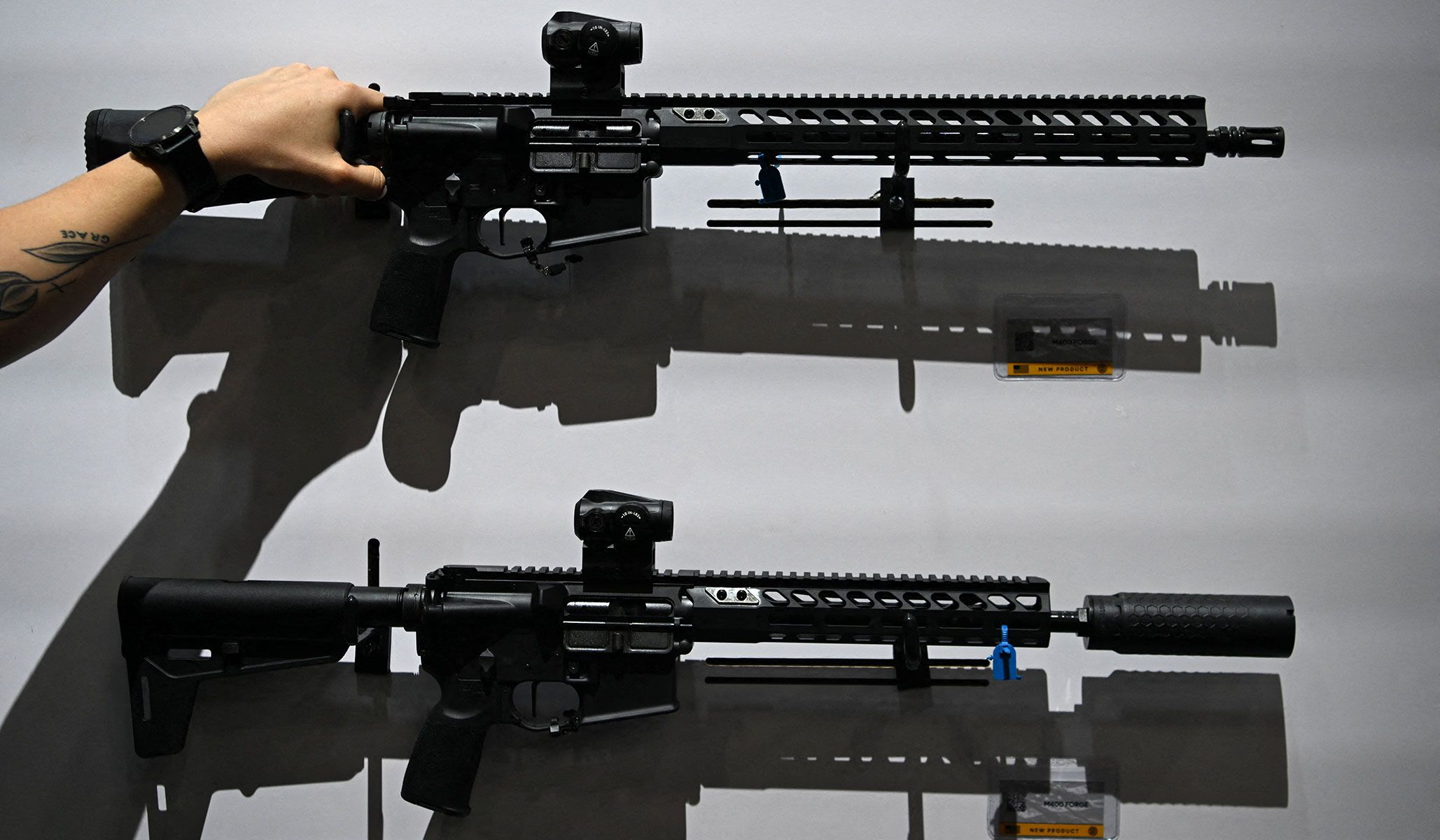An attendee handles a gun on display during the National Rifle Association's annual meetings and exhibits in Houston, Texas, April 17, 2026.