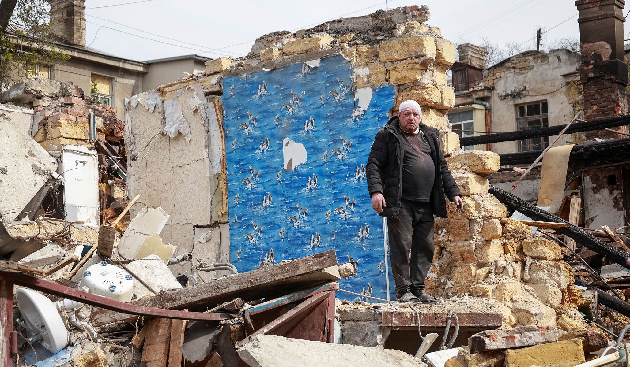 A wounded resident stands at the site of an apartment building hit by a Russian drone strike in Odesa, Ukraine, April 24, 2026.
