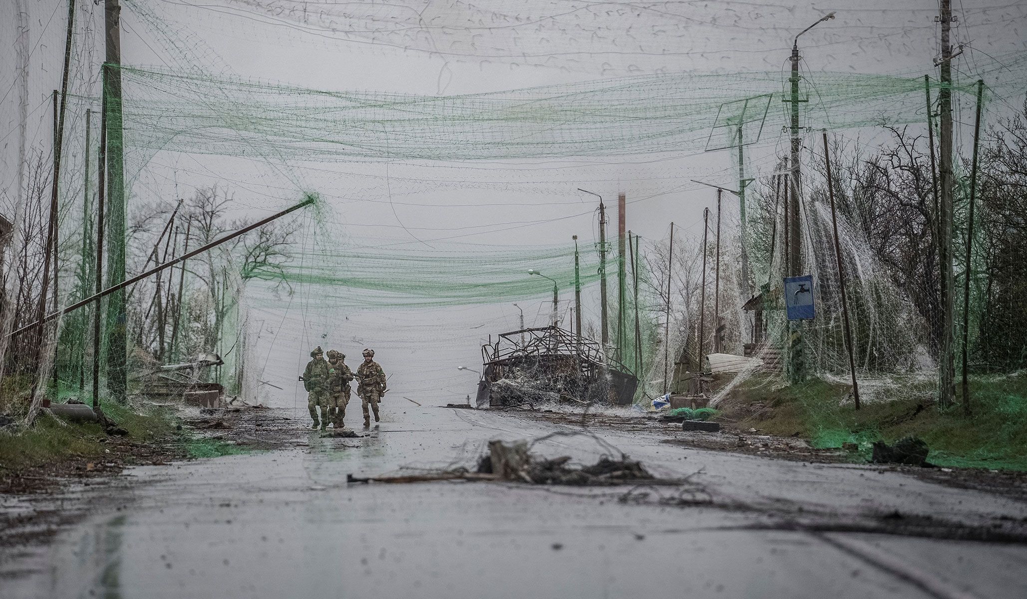 Servicemen of the 24th Separate Mechanized Brigade of the Ukrainian Armed Forces walk along a street under an anti-drone net net as they take part in a mission to protect streets for Russian drones in the frontline town of Druzhkivka, Donetsk Region, Ukraine, April 24, 2026.