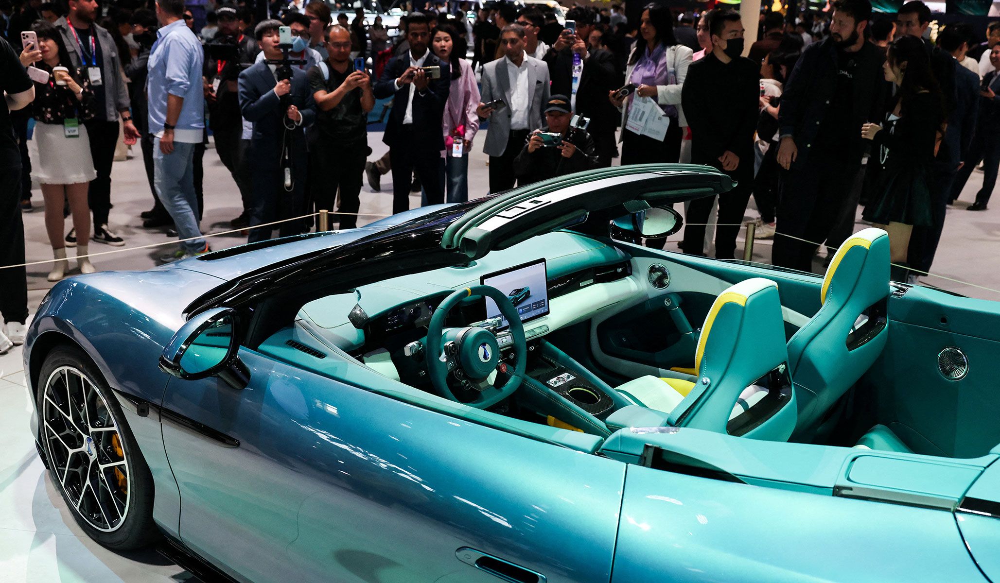 People gather next to the newly presented Z Convertible EV of BYD's luxury brand Denza at the Beijing International Automotive Exhibition in Beijing, China, April 24, 2026.