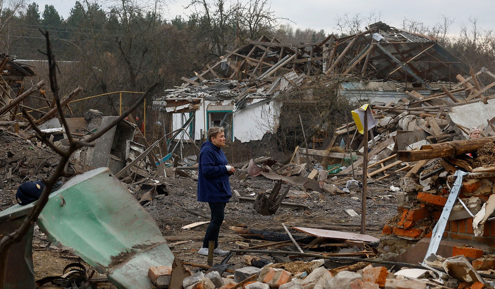 A resident stands next to her house, heavily damaged during a Russian missile strike in the town of Korosten, Zhytomy Region, Ukraine, April 3, 2026.