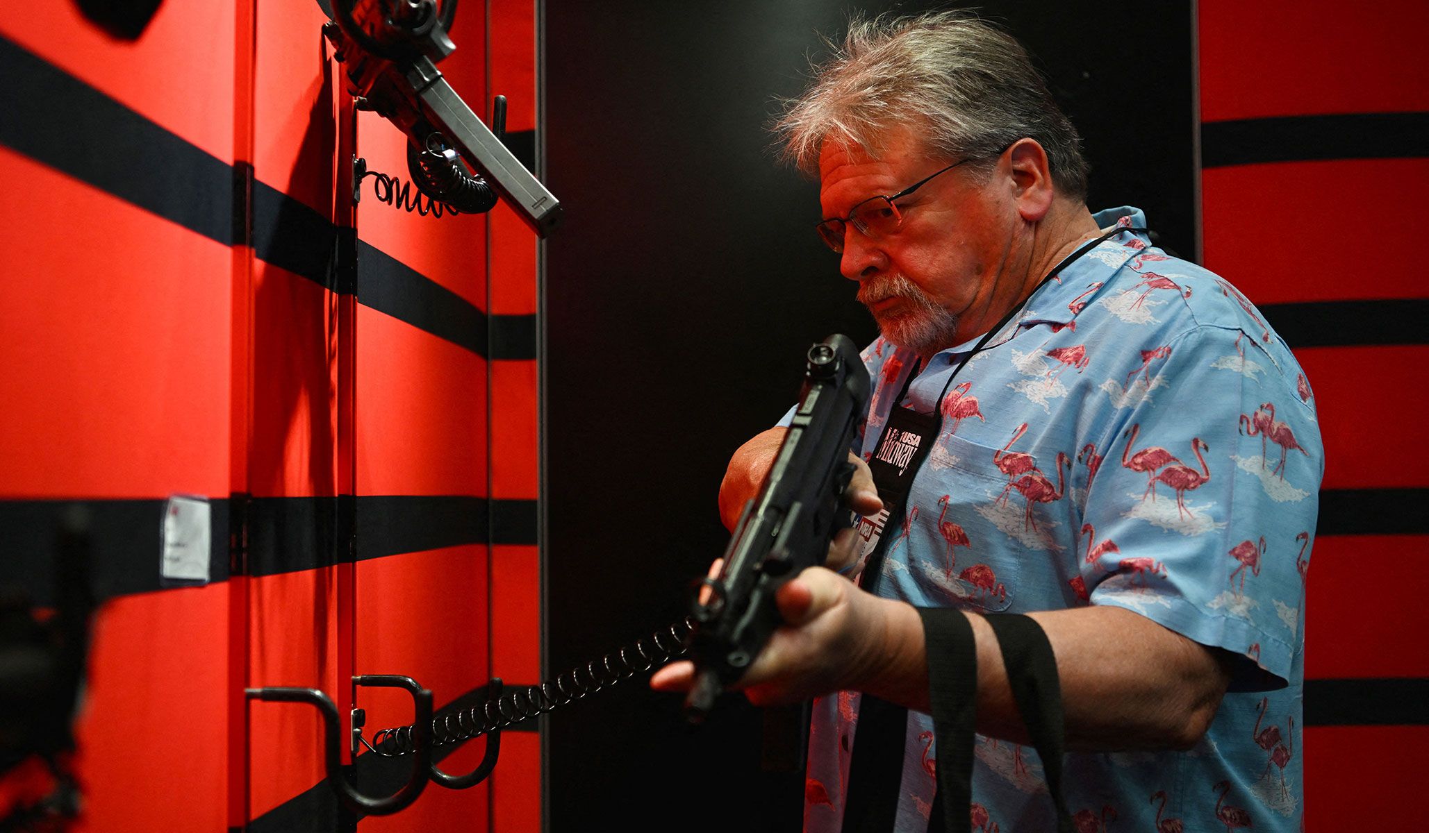 An attendee tests out a weapon on display as people attend the National Rifle Association's annual meetings and exhibits in Houston, Texas, April 17, 2026.