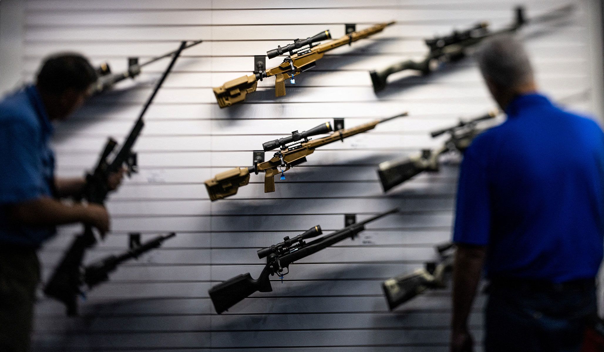 Visitors look at assault rifles during the NRA annual meetings and exhibits in Houston, Texas, April 17, 2026.