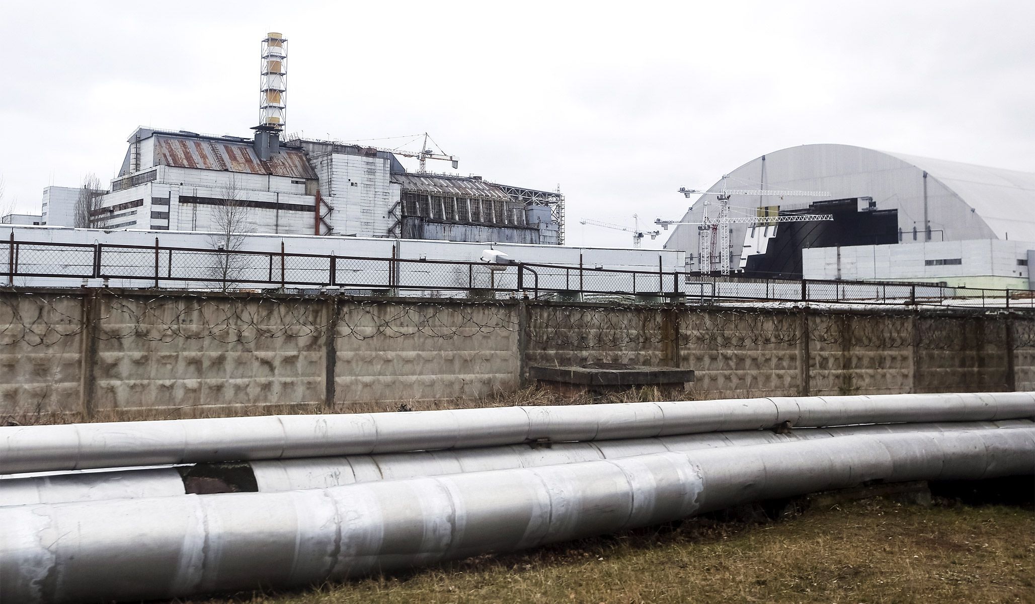 The containment shelter for the damaged fourth reactor (left) and the New Safe Confinement structure (right) at the Chernobyl nuclear power plant in Ukraine, March 23, 2016.