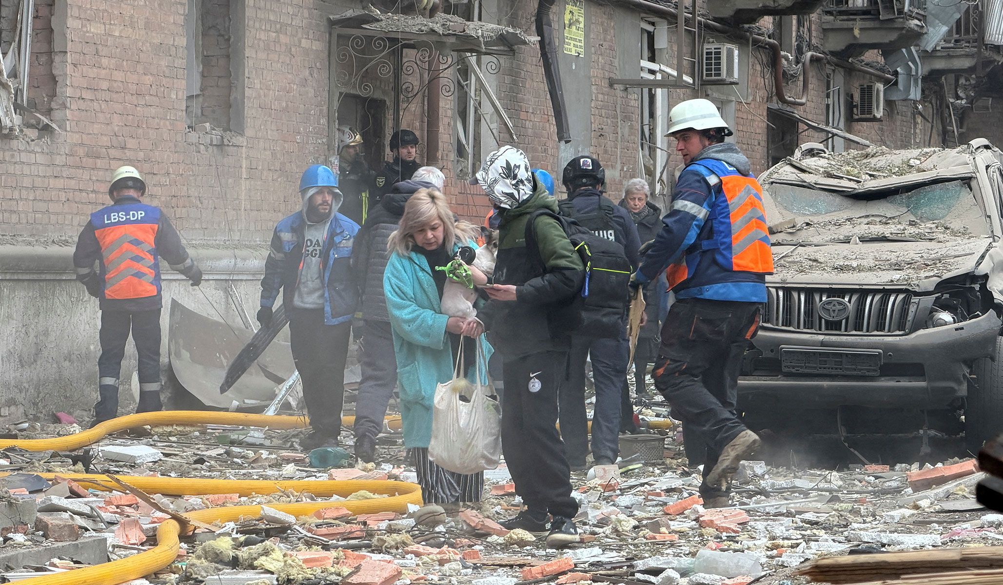 Residents leave the site of an apartment building hit by a Russian drone and missile strike in Dnipro, Ukraine, April 25, 2026. Picture taken with a mobile phone.