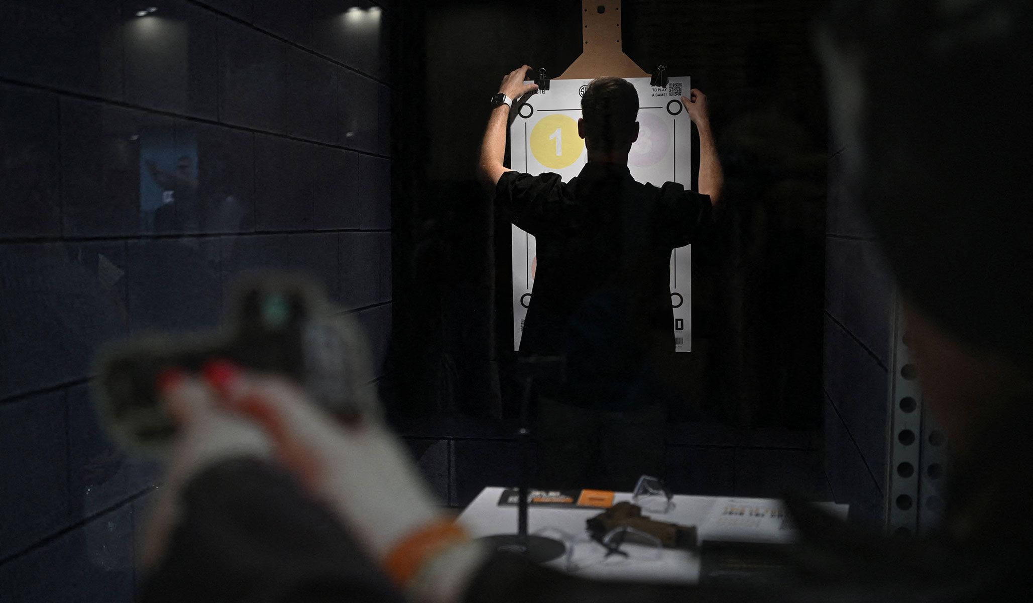 An exhibitor replaces a piece of paper used for target practice as people attend the National Rifle Association's annual meetings and exhibits in Houston, Texas, April 17, 2026.
