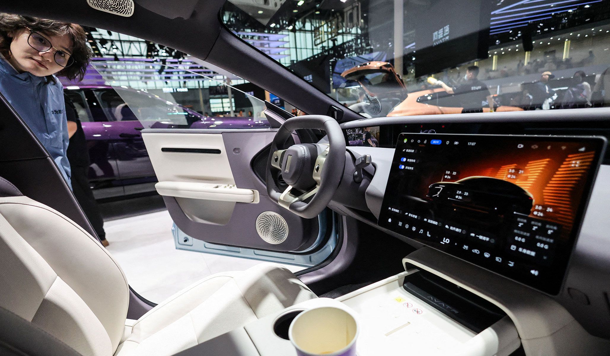 A woman looks inside the newly presented Avatr 06T electric car at the Beijing International Automotive Exhibition in Beijing, China, April 24, 2026.