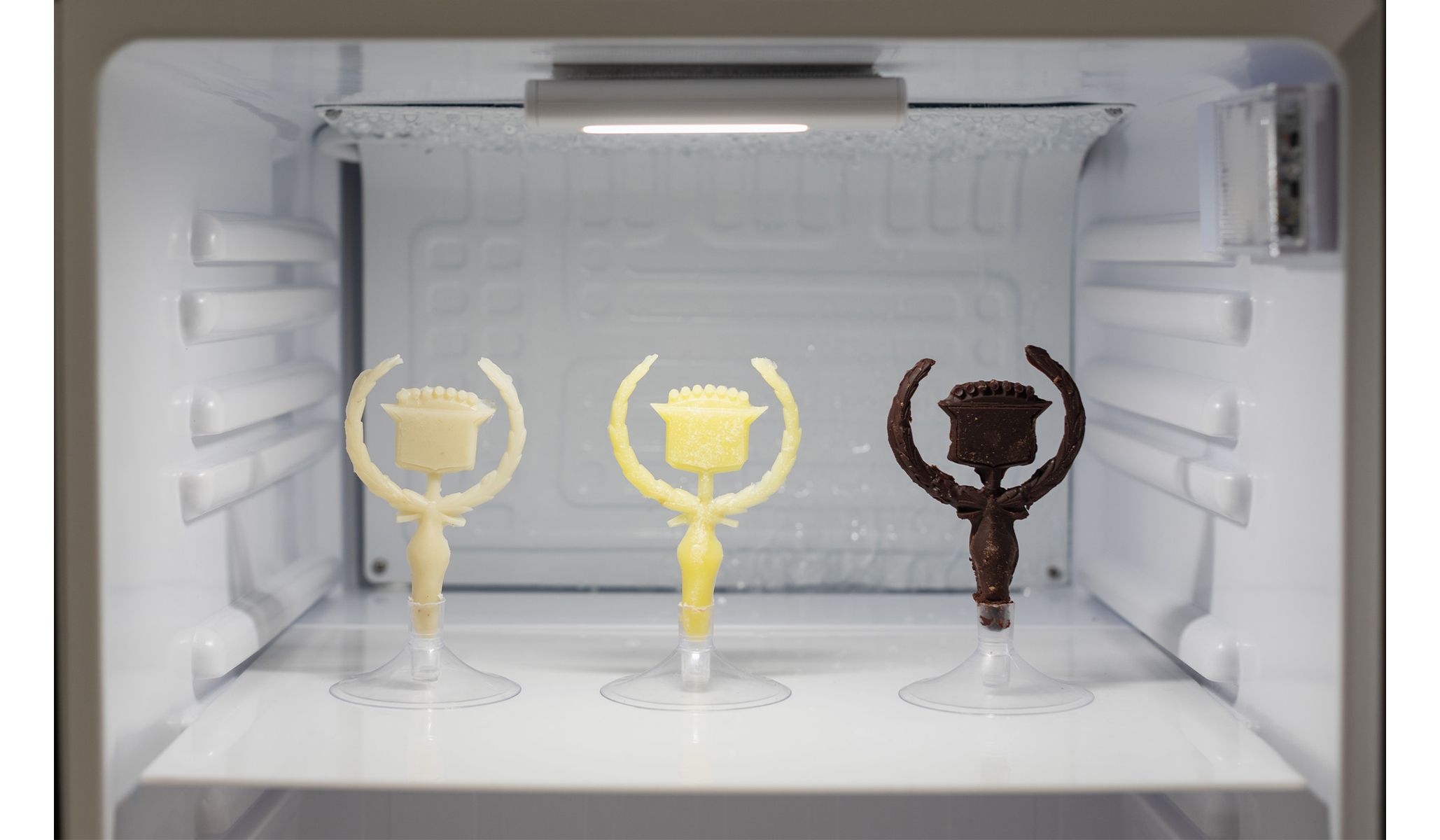 Chocolate and butter Cadillac hood ornaments in Ash Arder’s Consumables (detail) , 2023.