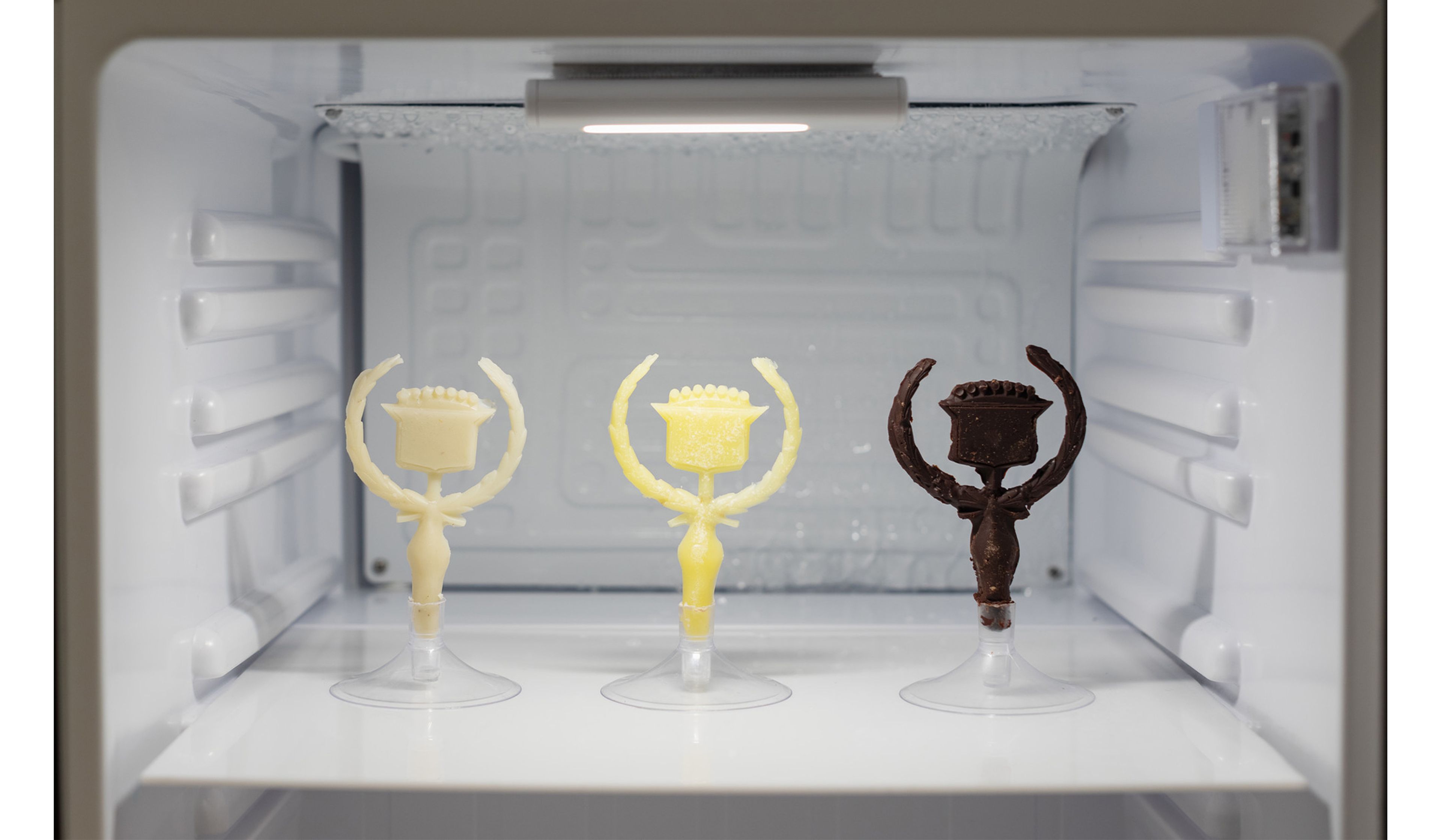 Chocolate and butter Cadillac hood ornaments in Ash Arder’s Consumables (detail) , 2023.