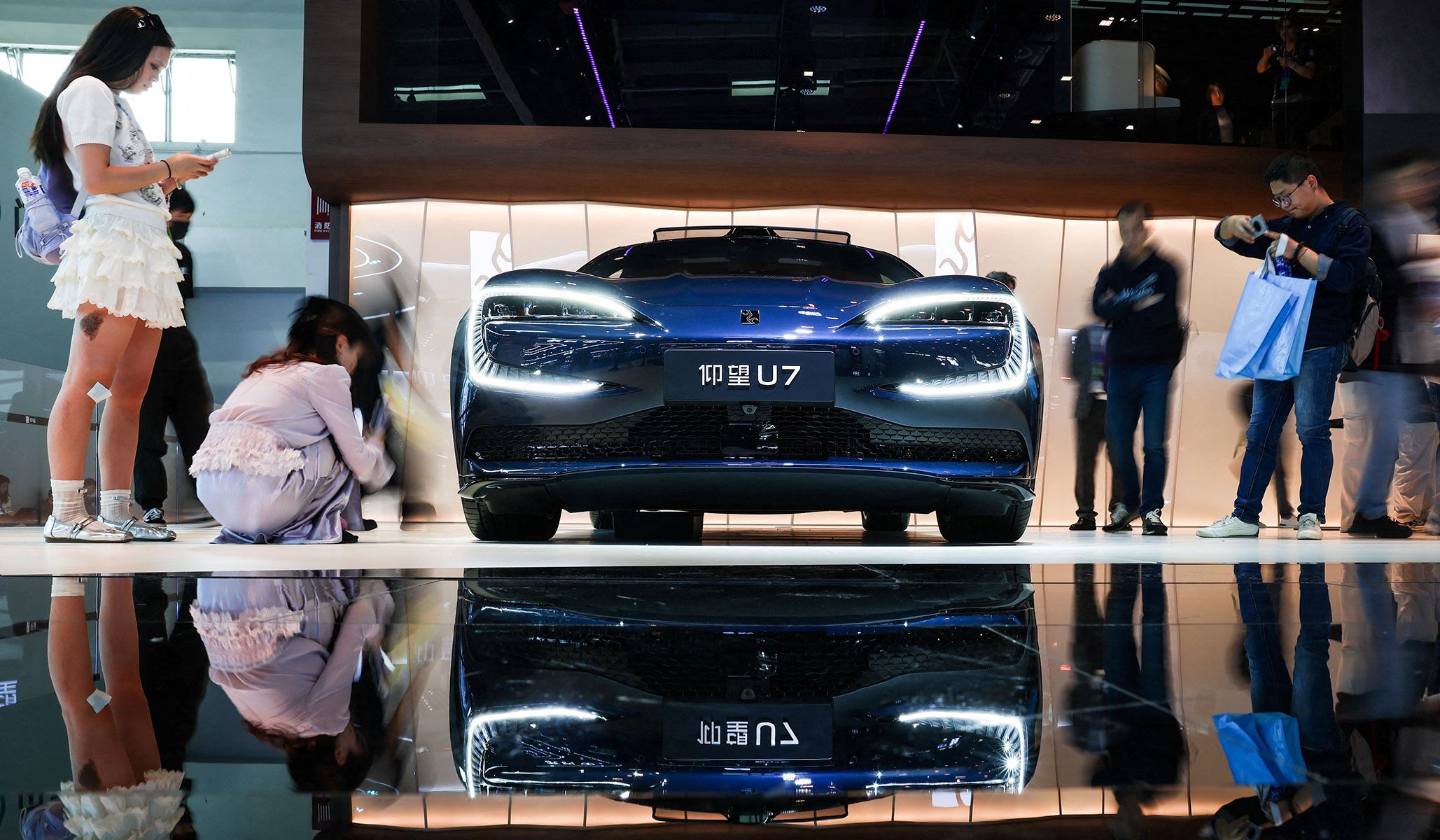 People gather next to BYD’s premium brand Yangwang's model U7 at the Beijing International Automotive Exhibition in Beijing, China, April 24, 2026.