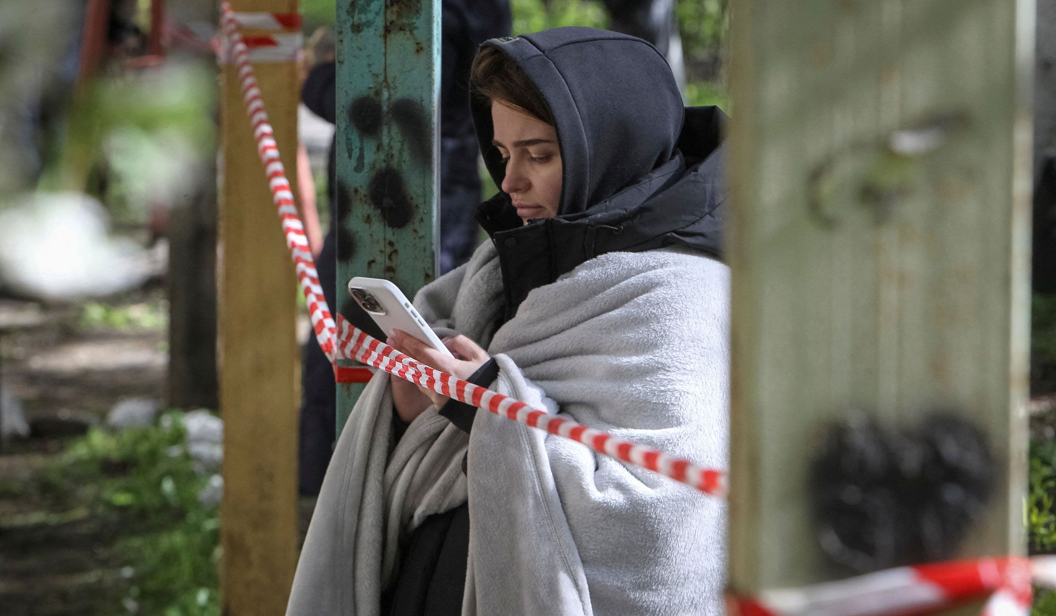 A resident stands at a site of an apartment building hit by a Russian drone strike in Dnipro, Ukraine, April 23, 2026.