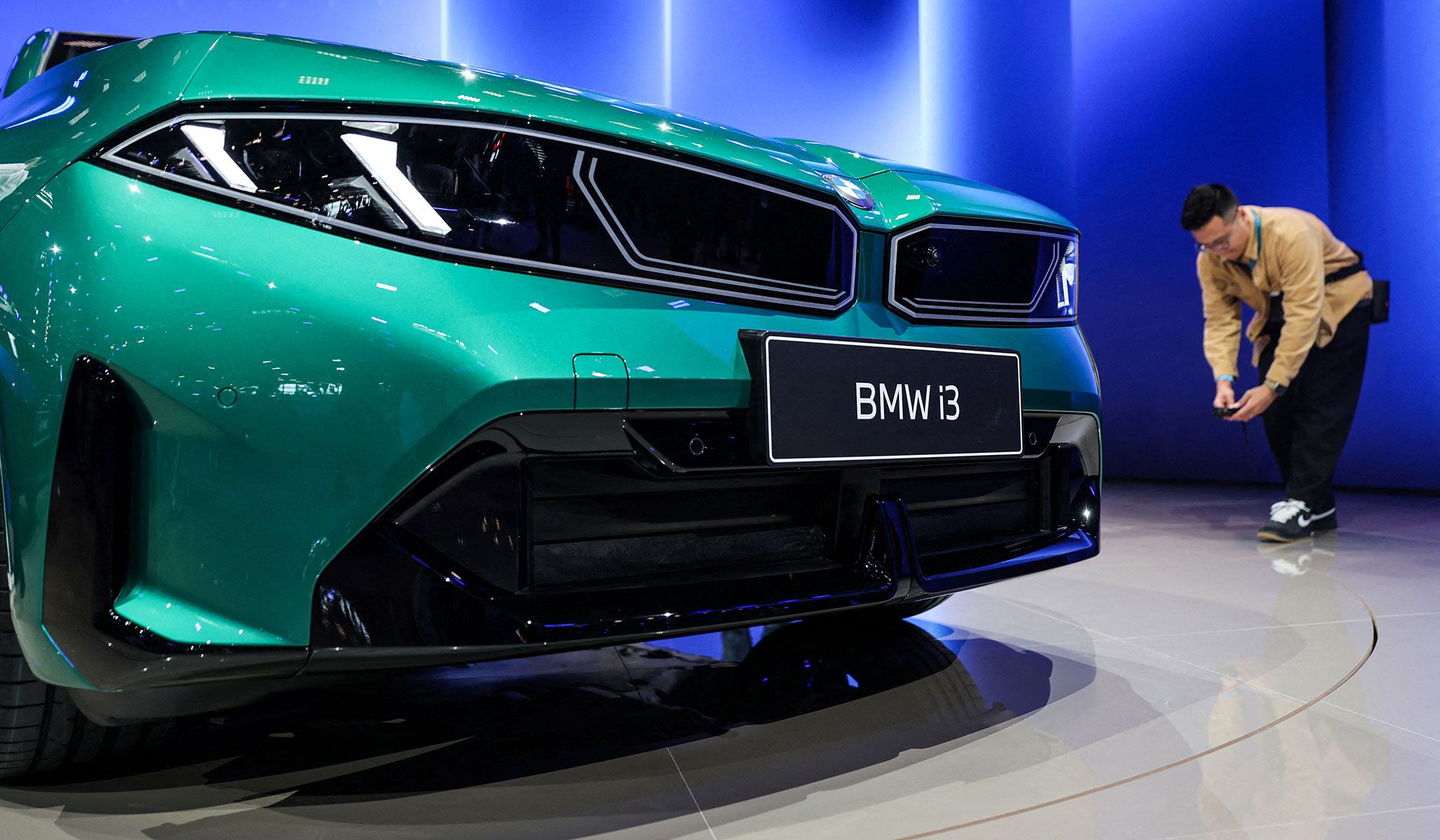 A man films the newly presented BMW i3 Long Wheelbase at the Beijing International Automotive Exhibition in Beijing, China, April 24, 2026.