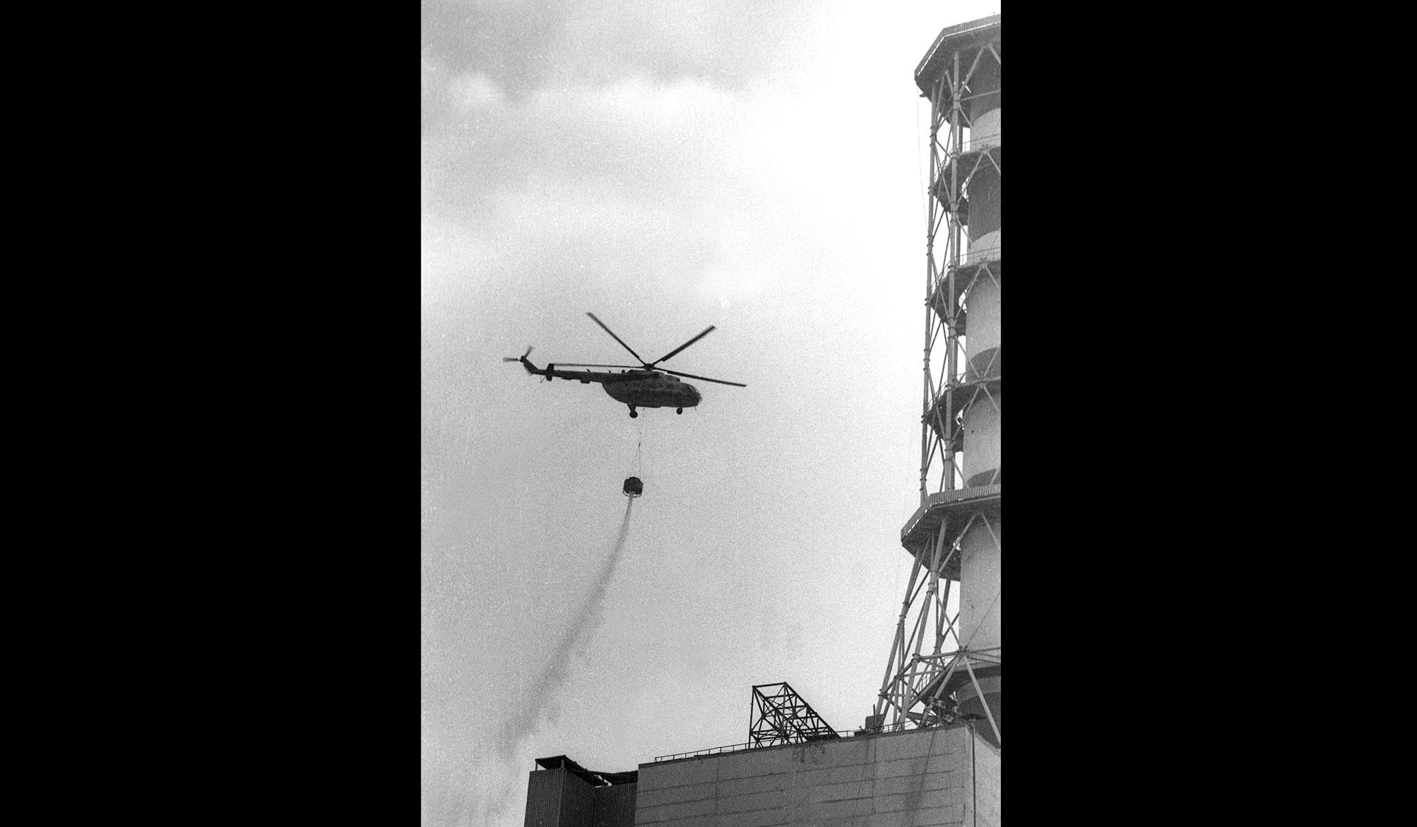 A helicopter drops concrete onto the fourth reactor of the Chernobyl nuclear power plant after its explosion, 1986.