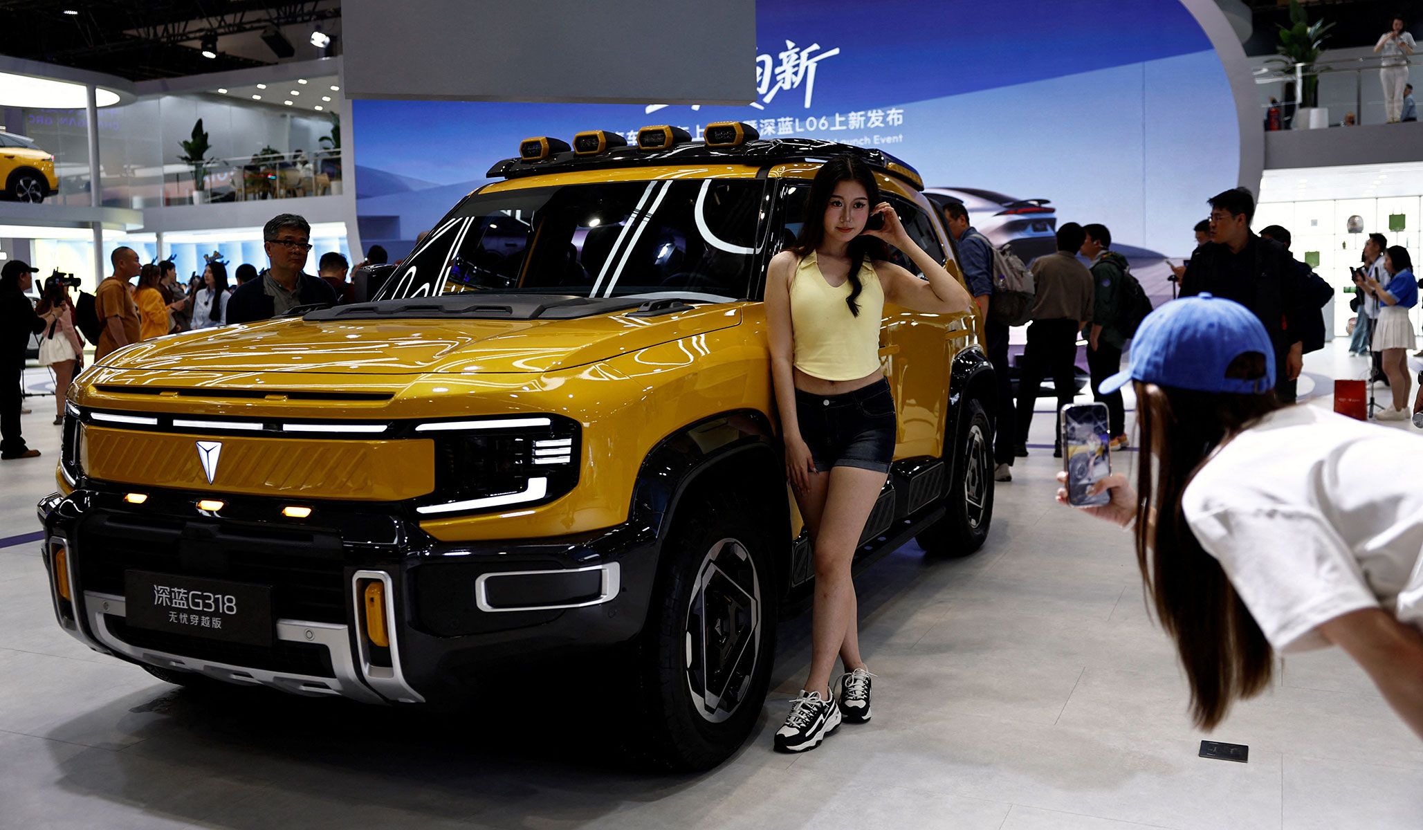 A woman poses with a Deepal G318 SUV at the Beijing International Automotive Exhibition in Beijing, China, April 24, 2026.