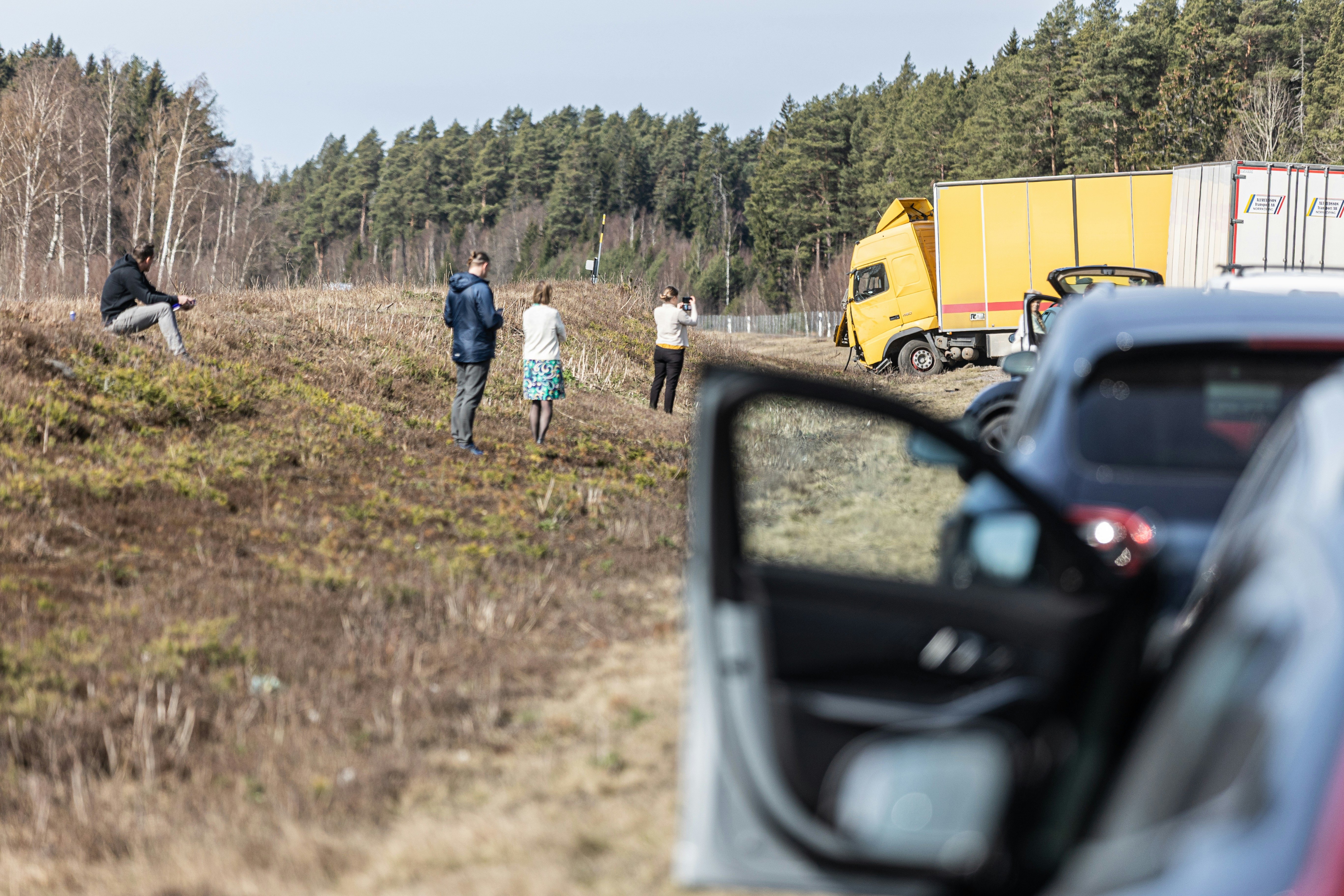 Image People standing near a crashed commercial truck off the road after a serious accident