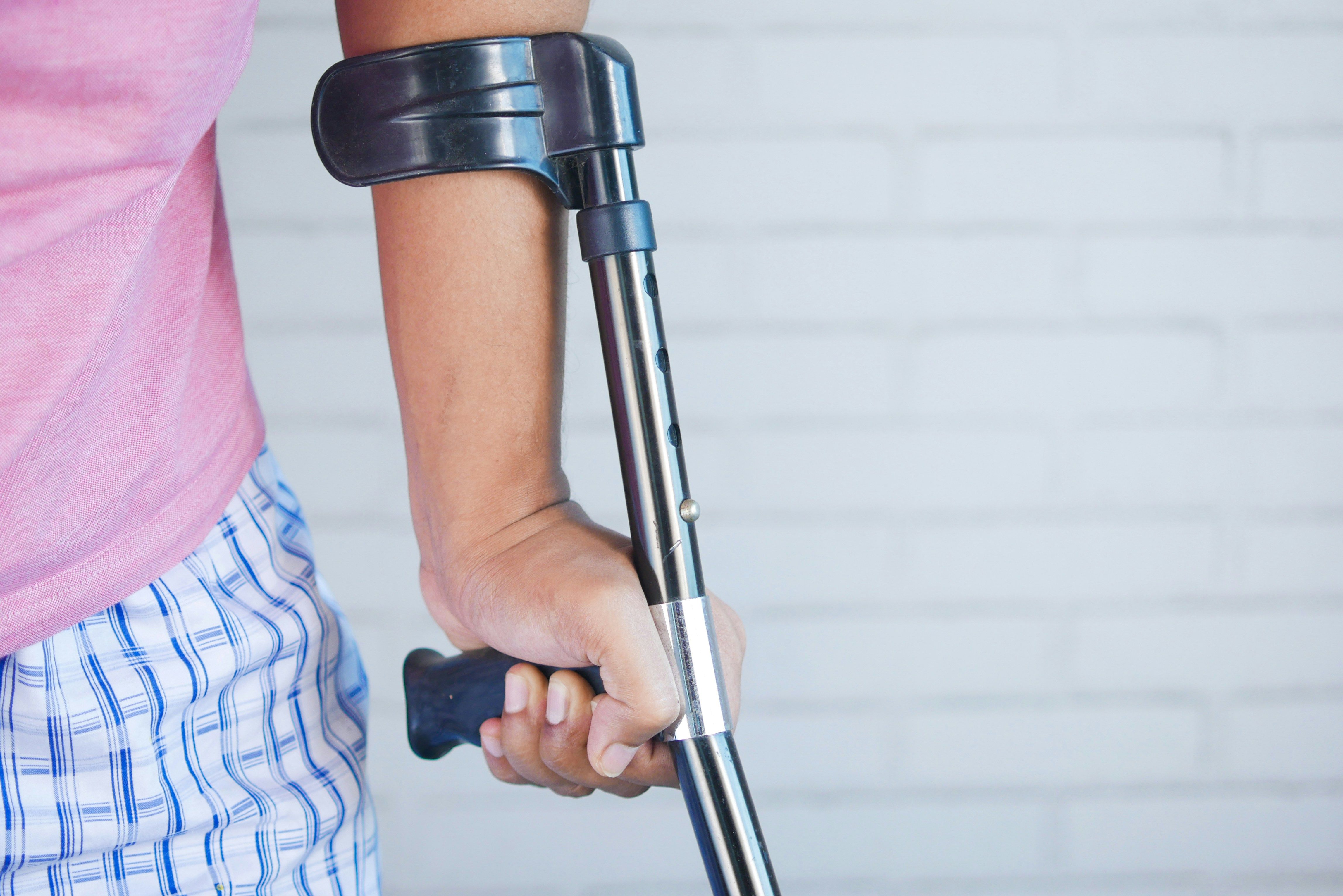 Injured rideshare passenger using a forearm crutch after an Uber or Lyft accident in New Jersey