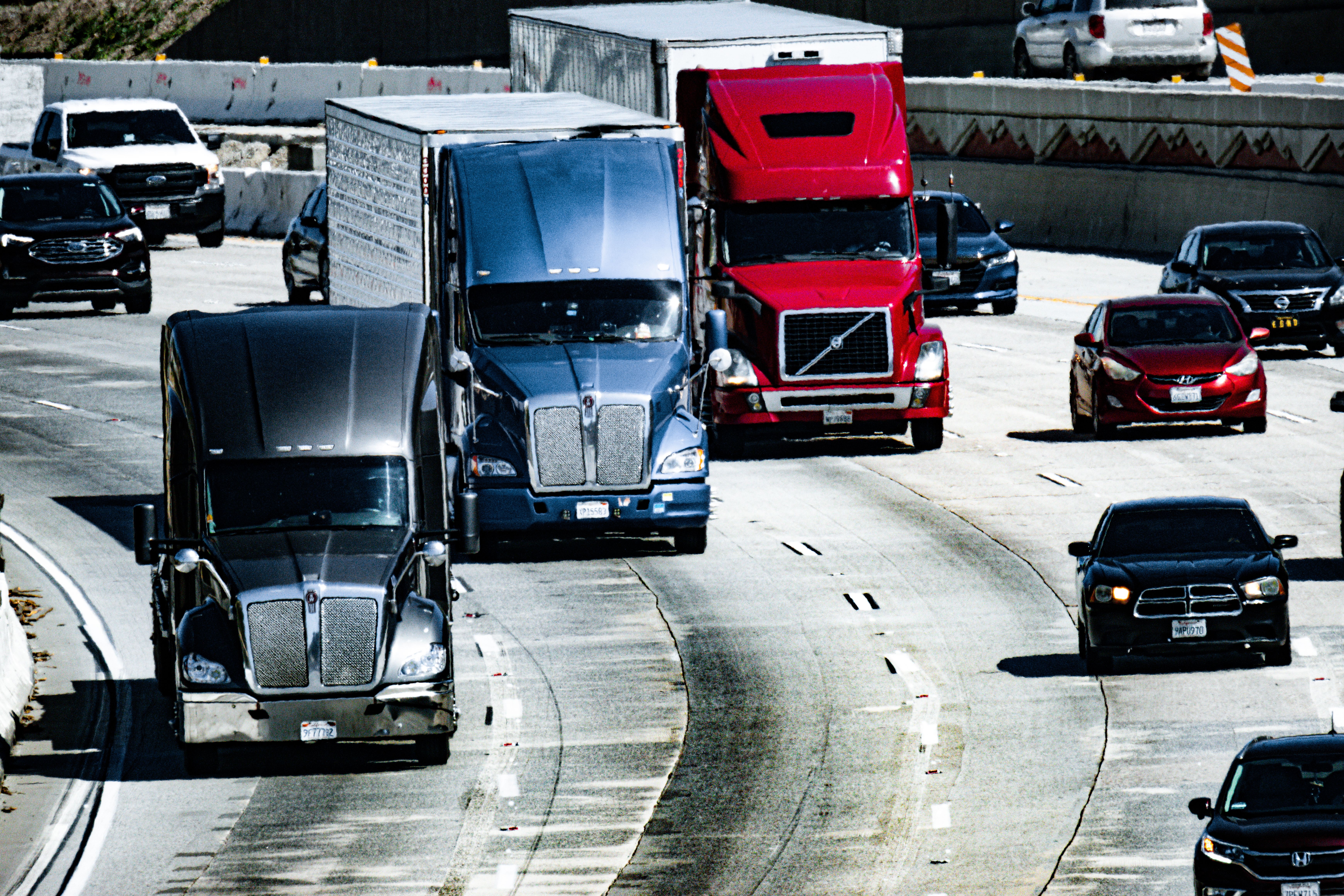 Image Commercial trucks merging with traffic on a busy highway, highlighting the risks of a New Jersey Turnpike truck accident claim.