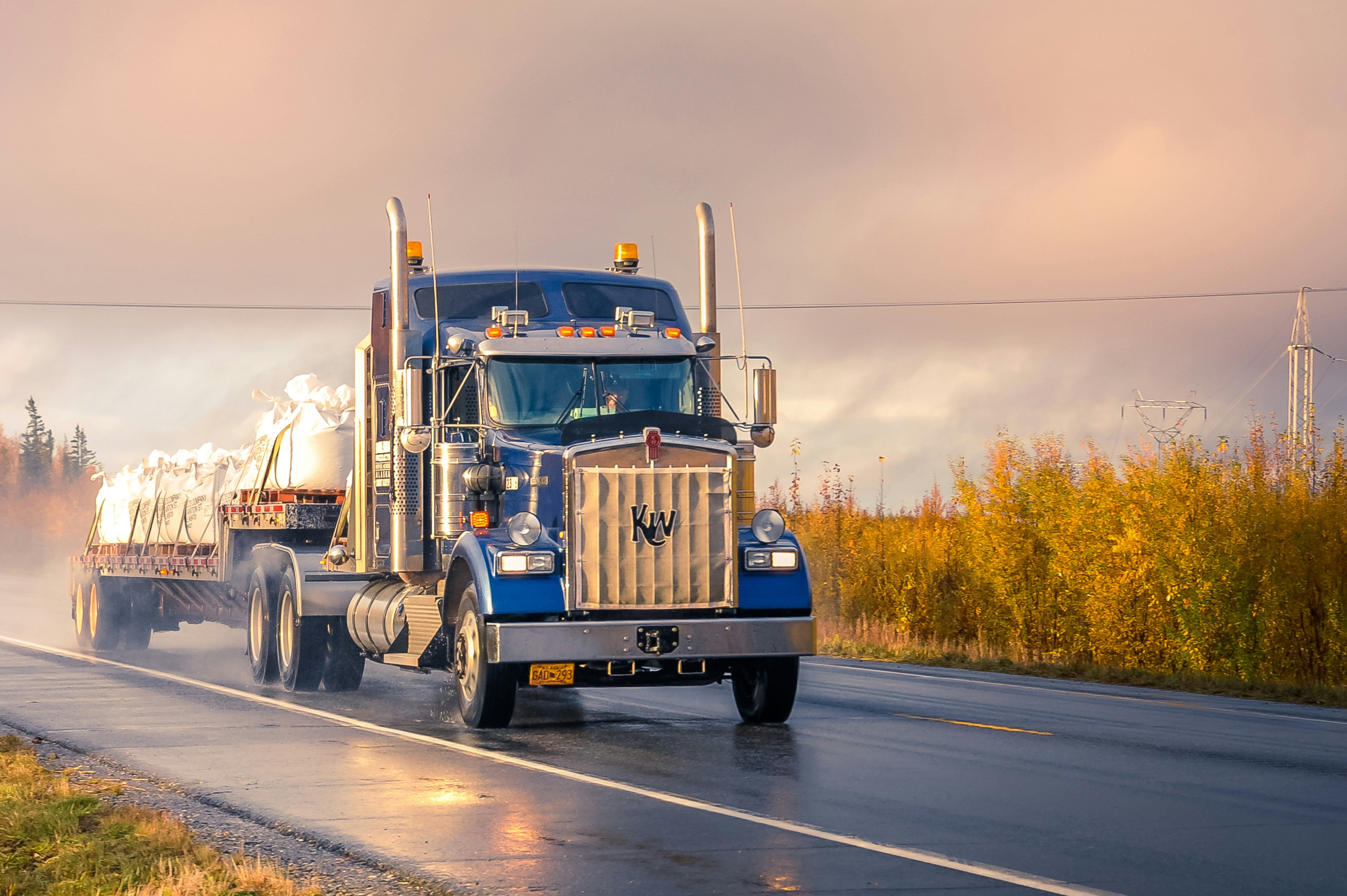 Tractor trailer hauling flatbed cargo on a wet highway, a common setting for New Jersey truck accident claims