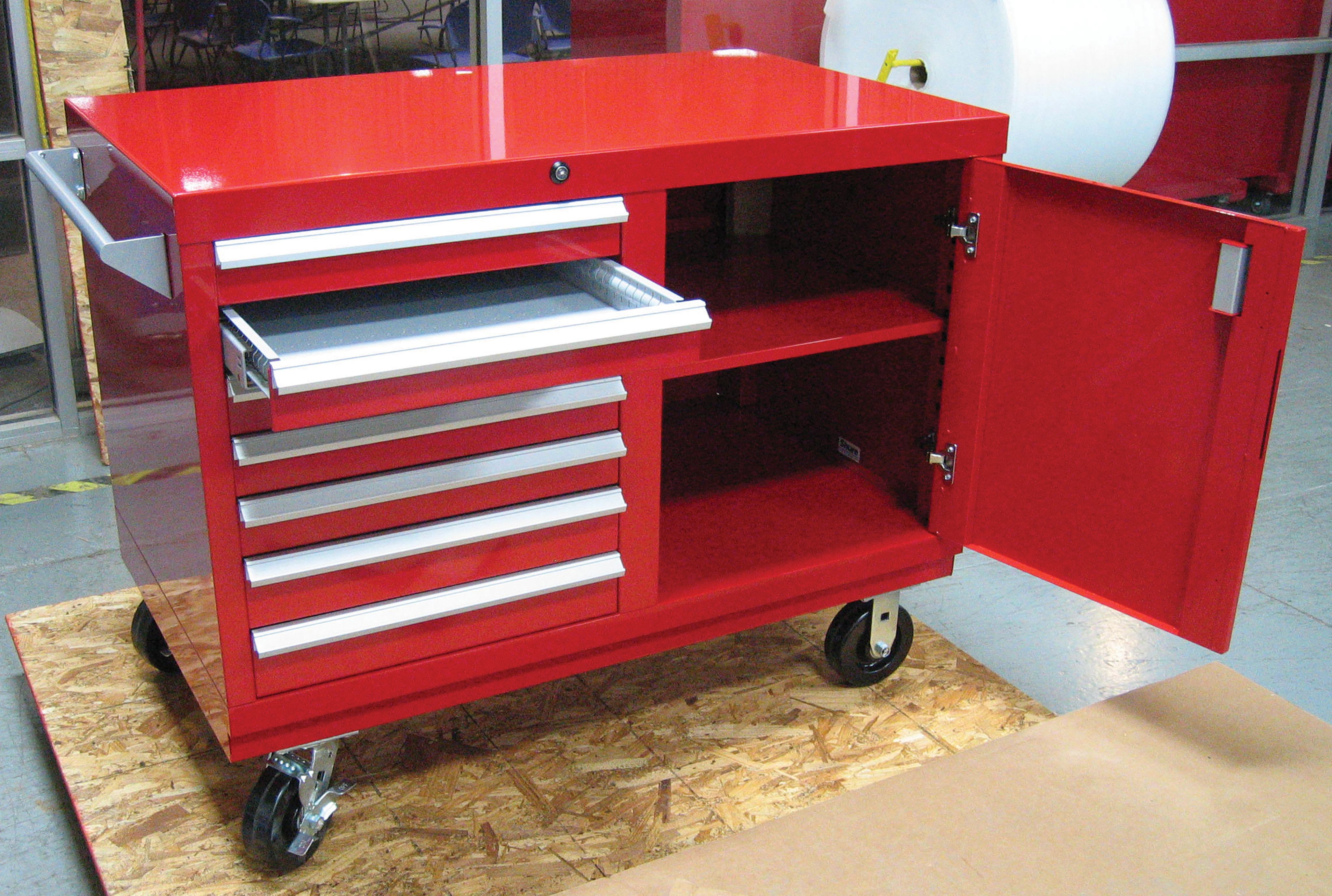 Red mobile steel cabinet on casters with an open drawer and an open shelf compartment