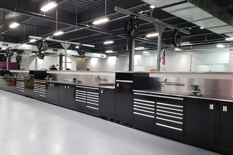 Long run of black steel cabinets and stainless-steel workbench tops in a clean service shop