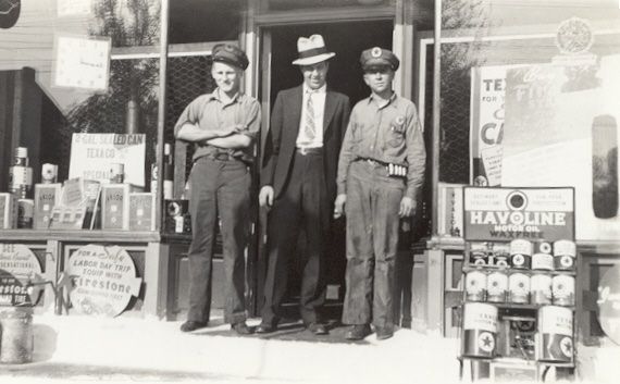 Archival photo of three men standing in the doorway of a Texaco service station