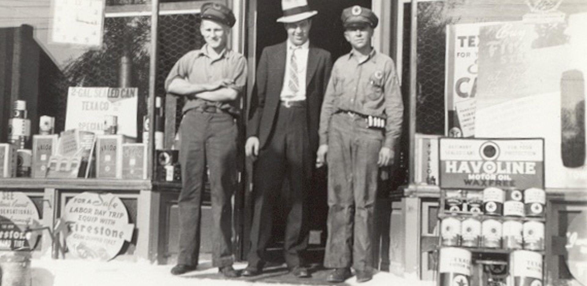 Archival photo of three men standing in the doorway of a Texaco service station