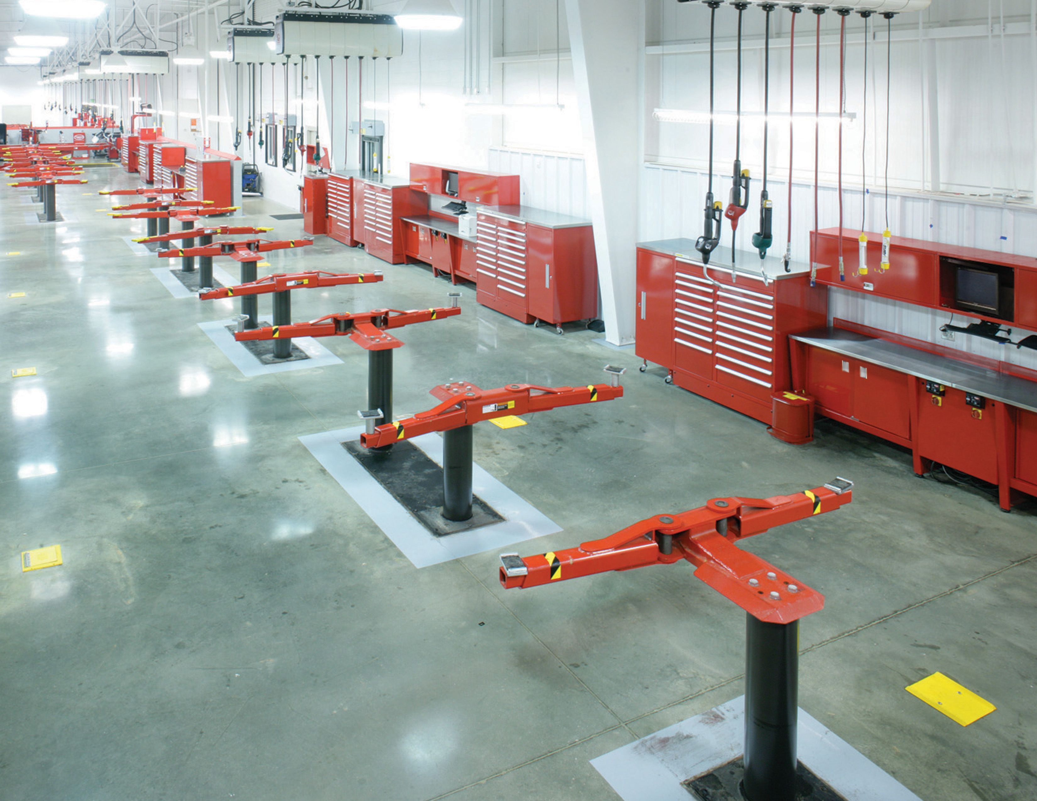 Service center with red powder-coated tool storage cabinets and red vehicle lifts