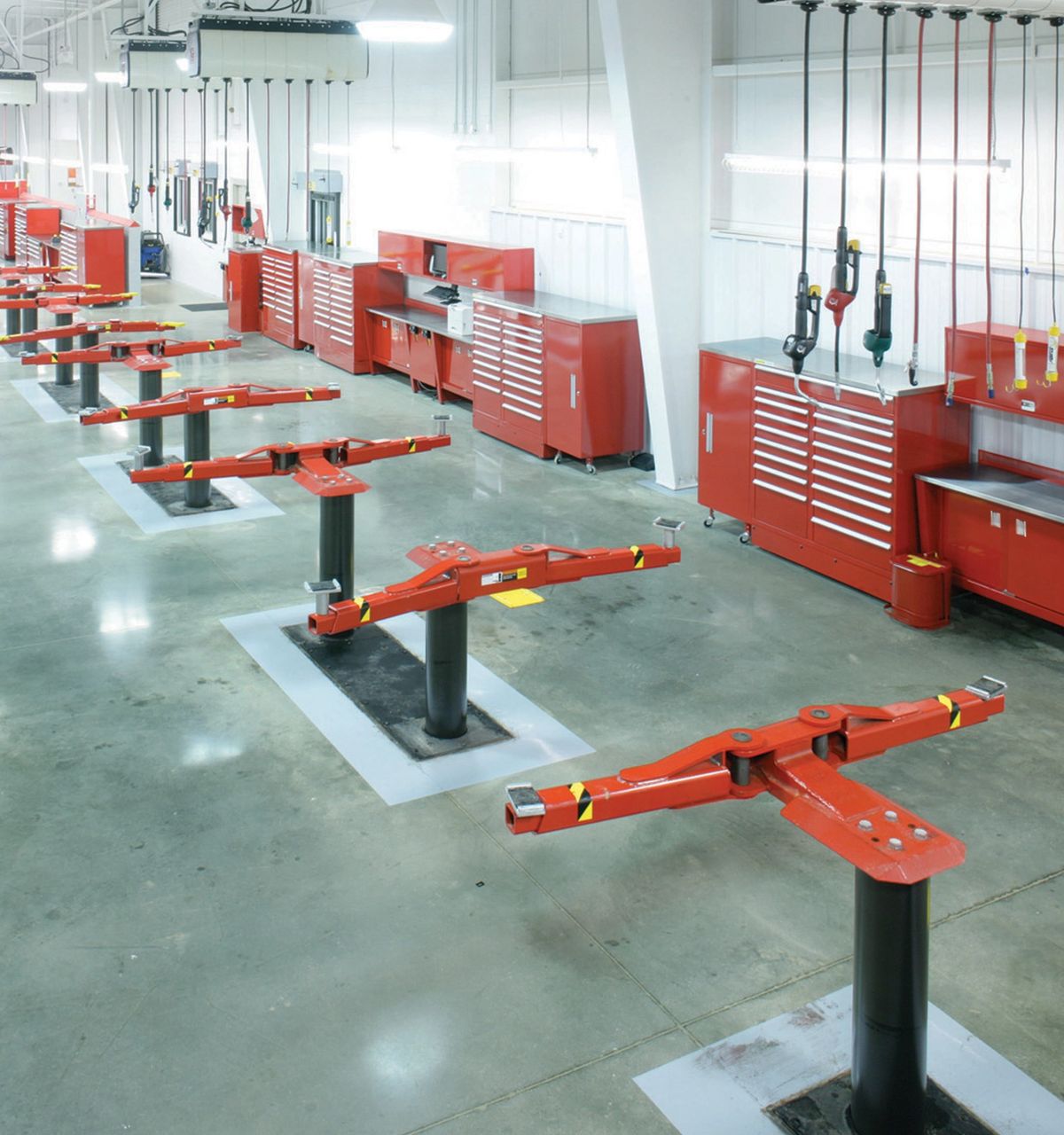 Service center with red powder-coated tool storage cabinets and red vehicle lifts
