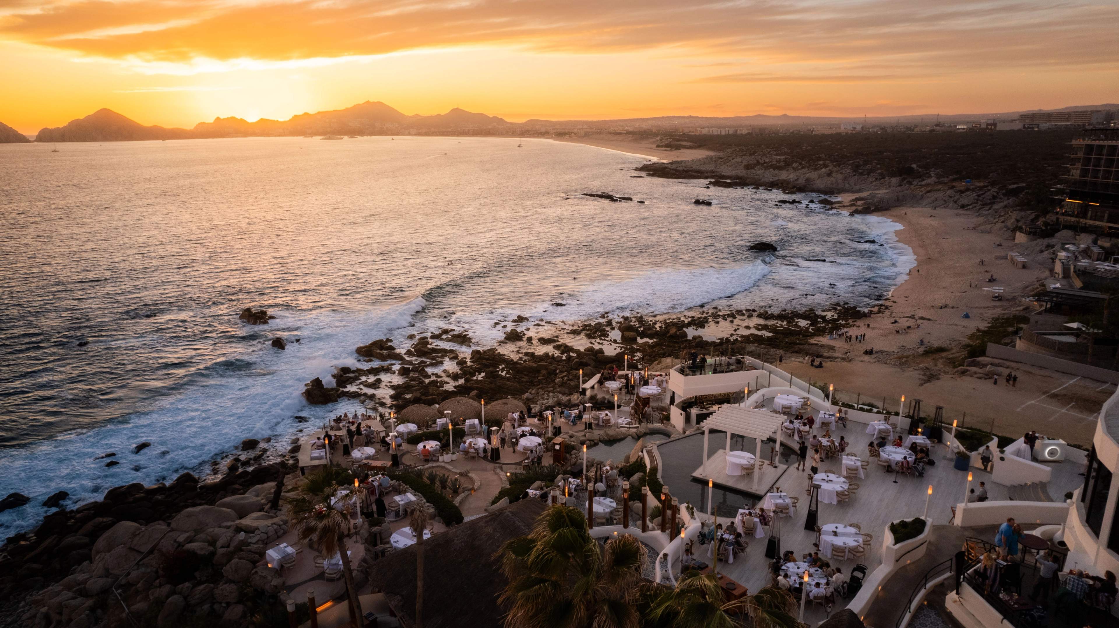 Puesta de sol cruzando la bahía sobre las terrazas de Sunset Monalisa