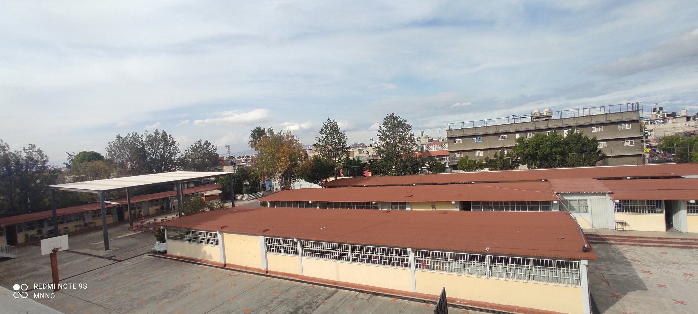 Fachada de una secundaria pública en la Ciudad de México, con patio, edificios de varios pisos y reja perimetral.