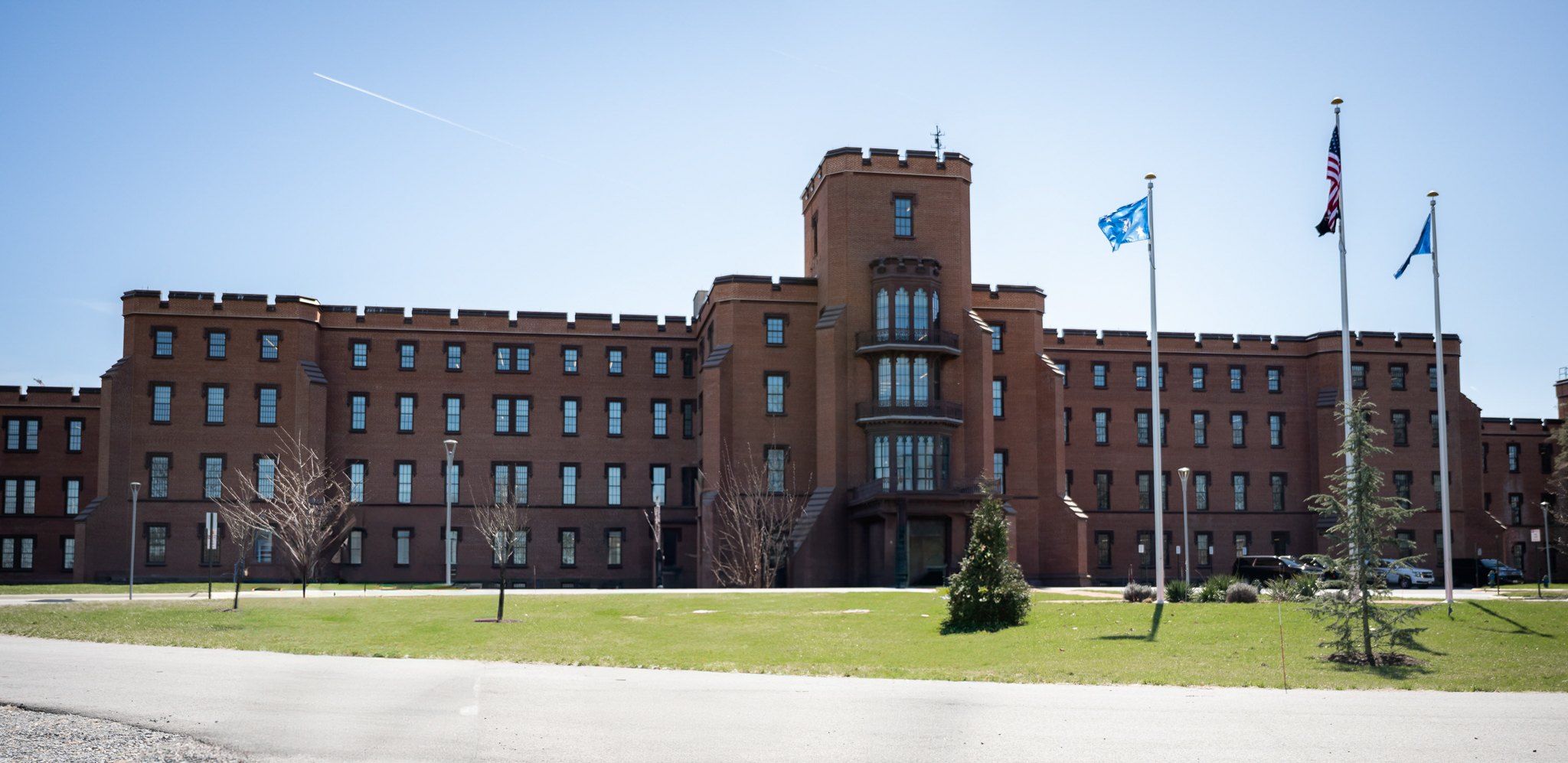 Edificio de ladrillo rojo con una torre central y astas con banderas, sede del Departamento de Seguridad Nacional de Estados Unidos en el campus St. Elizabeths, en Washington.