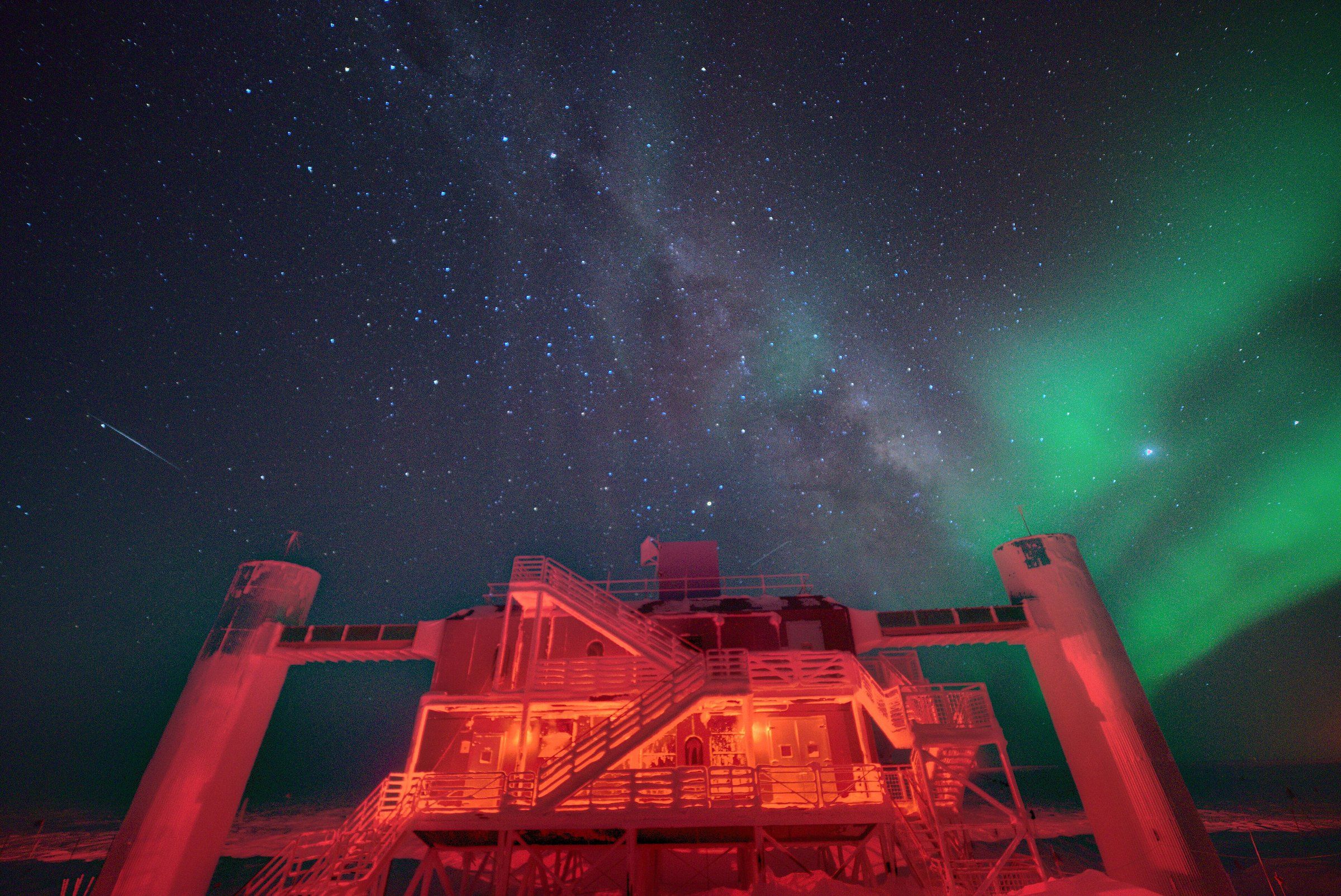 Laboratorio del observatorio de neutrinos IceCube, en el Polo Sur, de noche y bajo una aurora austral.