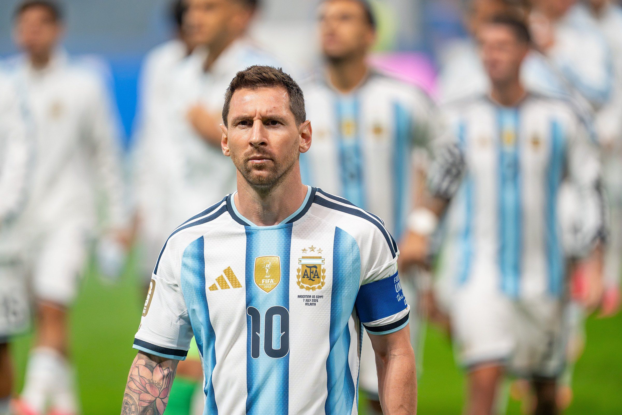 Lionel Messi, con la camiseta albiceleste número 10 y el brazalete de capitán, camina en la cancha seguido por sus compañeros de la selección argentina.