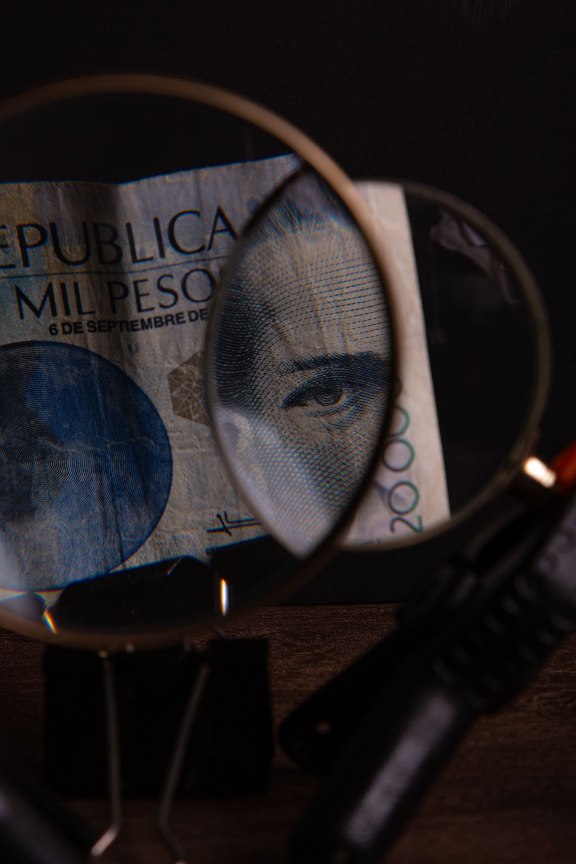 Una lupa amplía el detalle de un billete de mil pesos mexicanos.