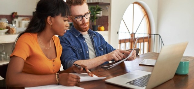 SLP professional working with a client at his desk