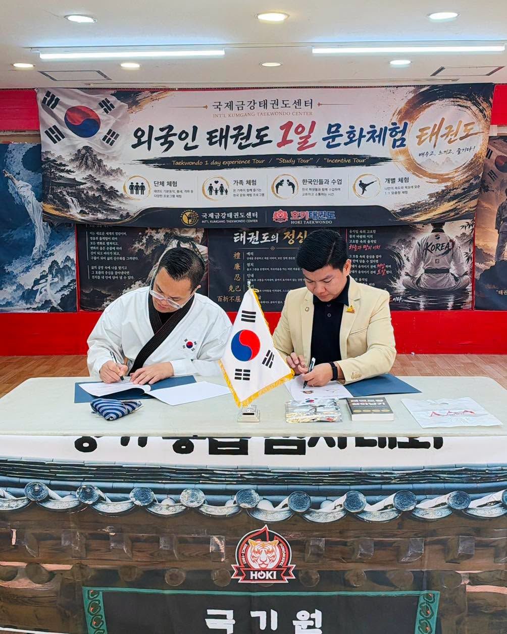 Representatives of AAA School and International Kumgang Taekwondo Center sign their agreement in Seoul.