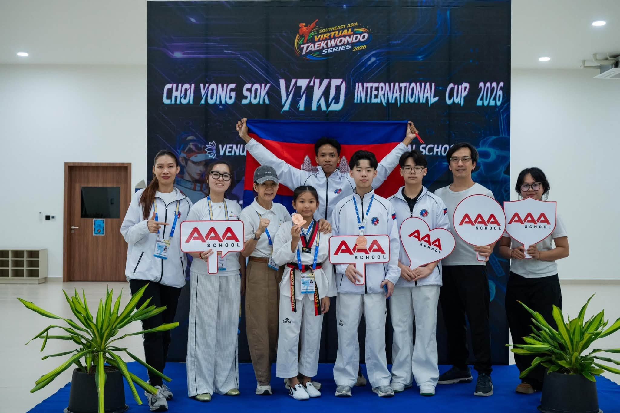 AAA Taekwondo students and supporters with the Cambodian flag at the Choi Yongsok VTKD International Cup 2026.