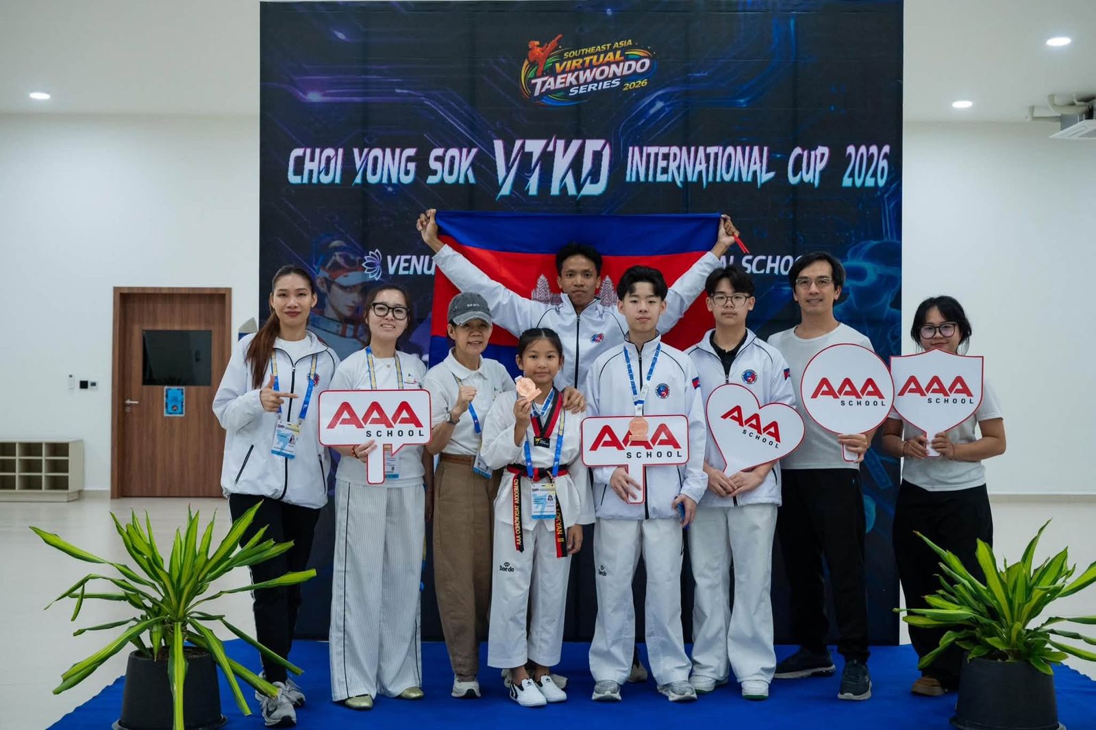 AAA Taekwondo students and supporters with the Cambodian flag at the Choi Yongsok VTKD International Cup 2026.