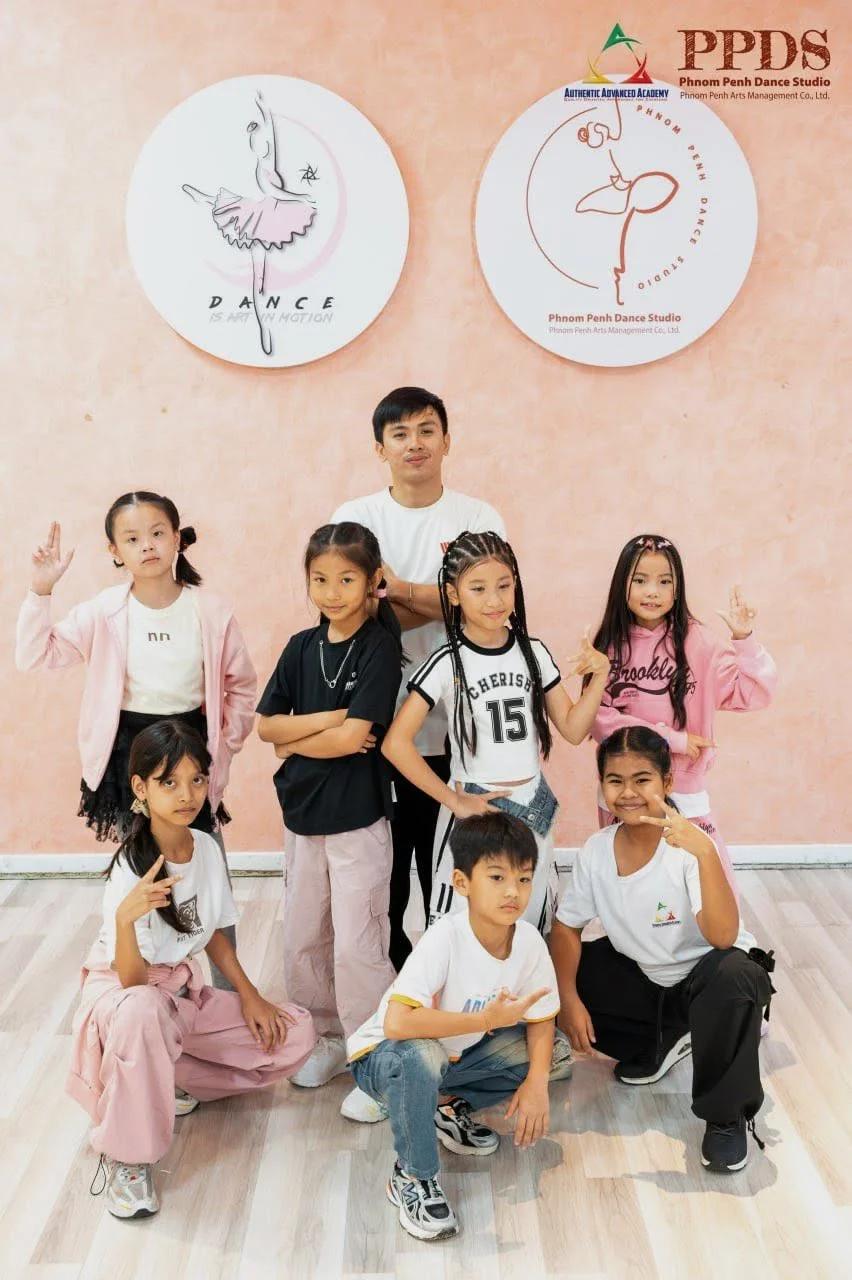 AAA Hip Hop students pose with their teacher in the dance studio.