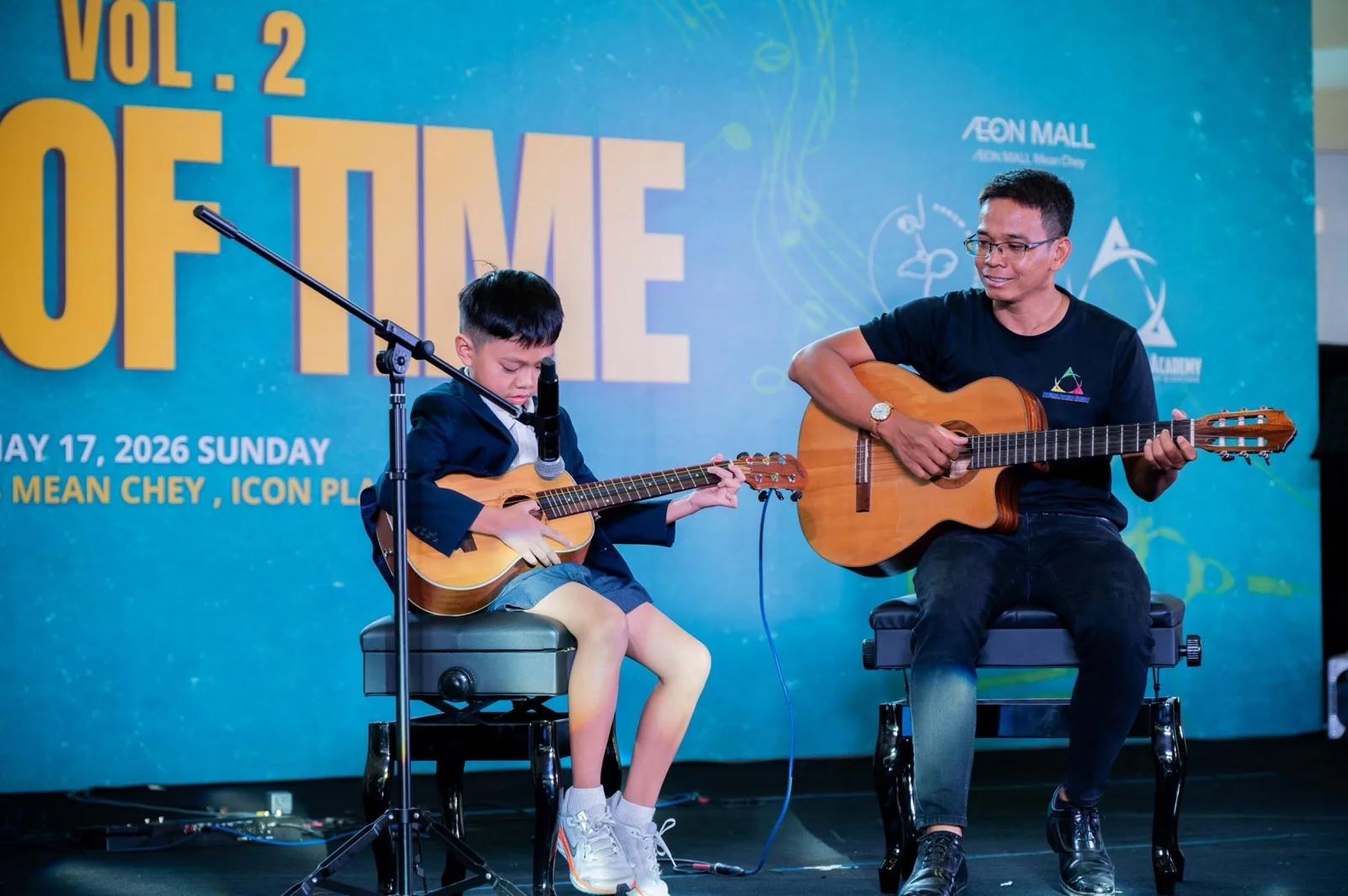 A student and teacher play guitar together at AAA’s Out of Time music performance.