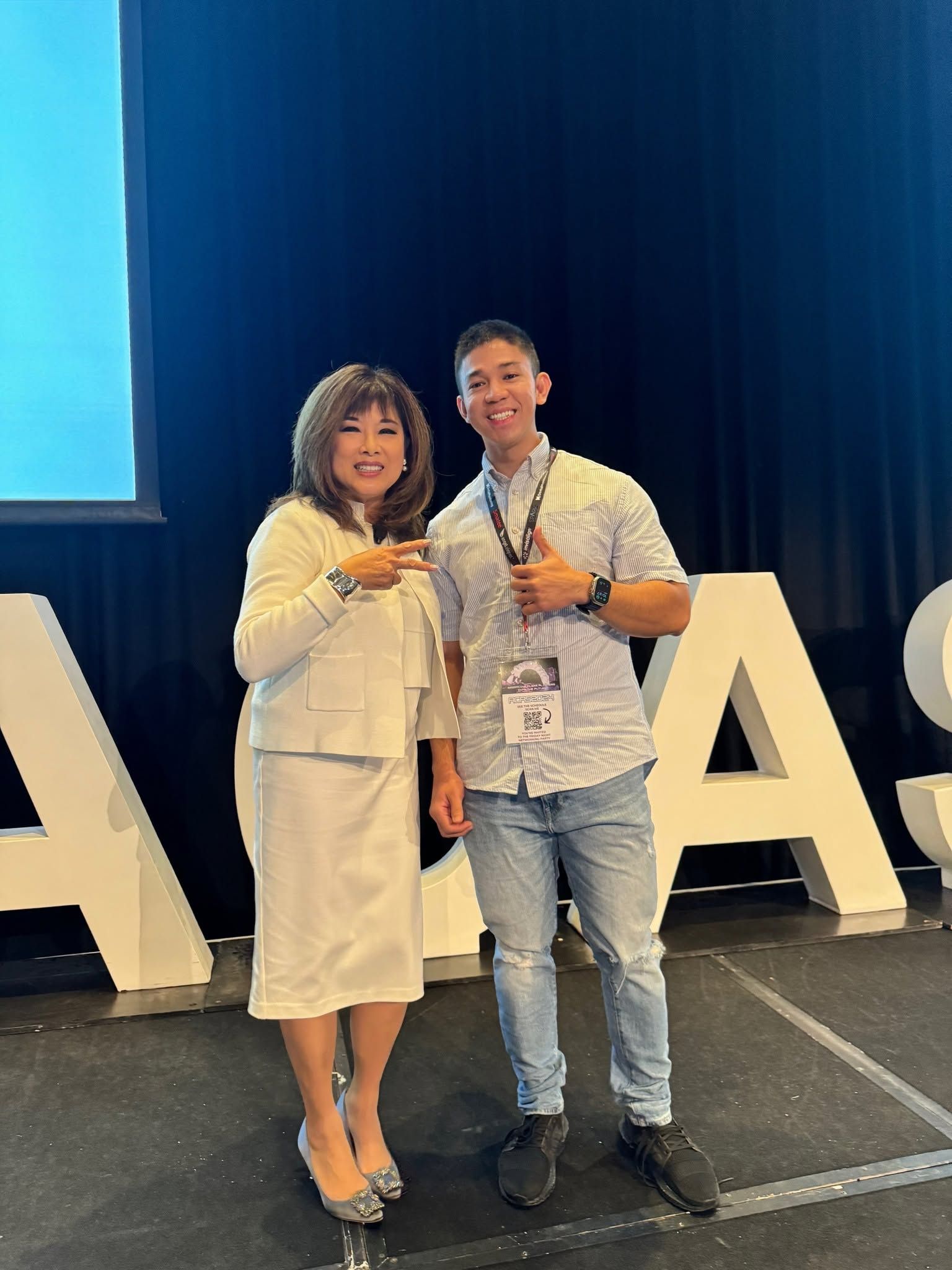 Dr Ho Le Bao An photographed with the conference keynote speaker in front of the oversized “ACAS” letters on stage.