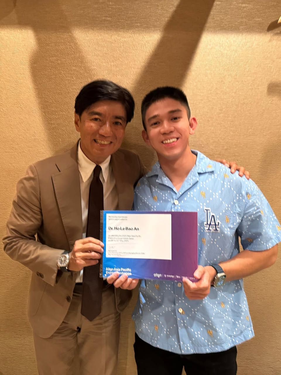 Bác sĩ Hồ Lê Bảo Ân cầm chứng nhận chương trình Align Asia Pacific Experience Exchange, đứng cùng một chuyên gia hướng dẫn.