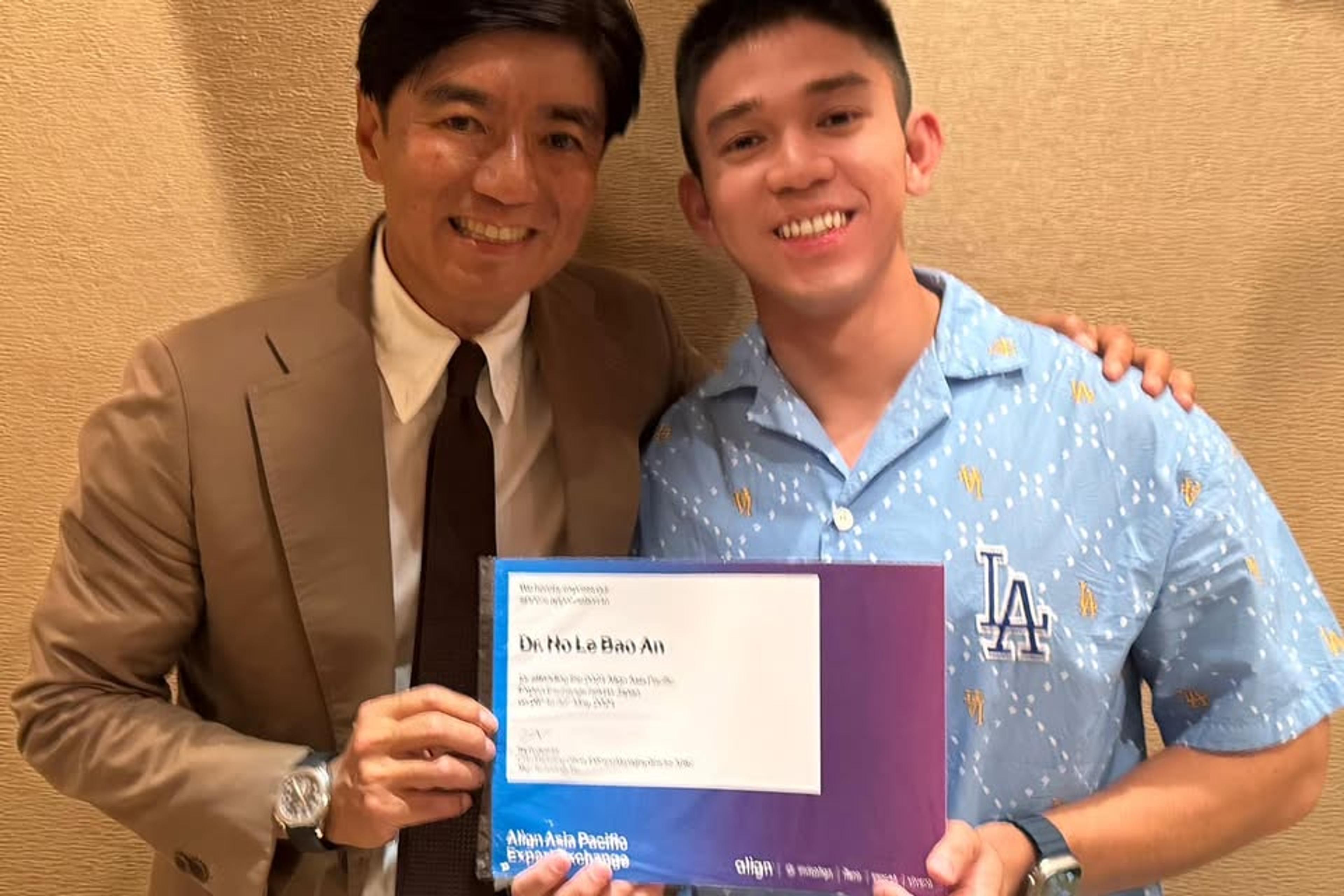 Bác sĩ Hồ Lê Bảo Ân cầm chứng nhận chương trình Align Asia Pacific Experience Exchange, đứng cùng một chuyên gia hướng dẫn.