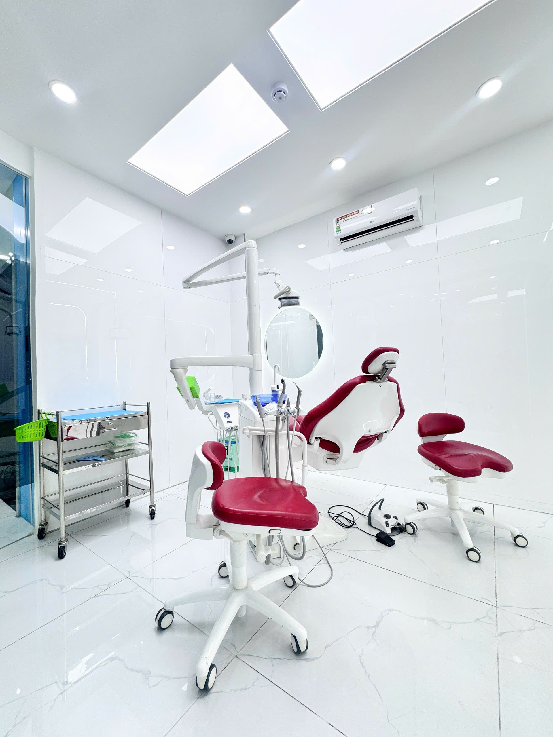 Phòng điều trị với ghế nha khoa và bàn dụng cụ tại Dr Tony Dental