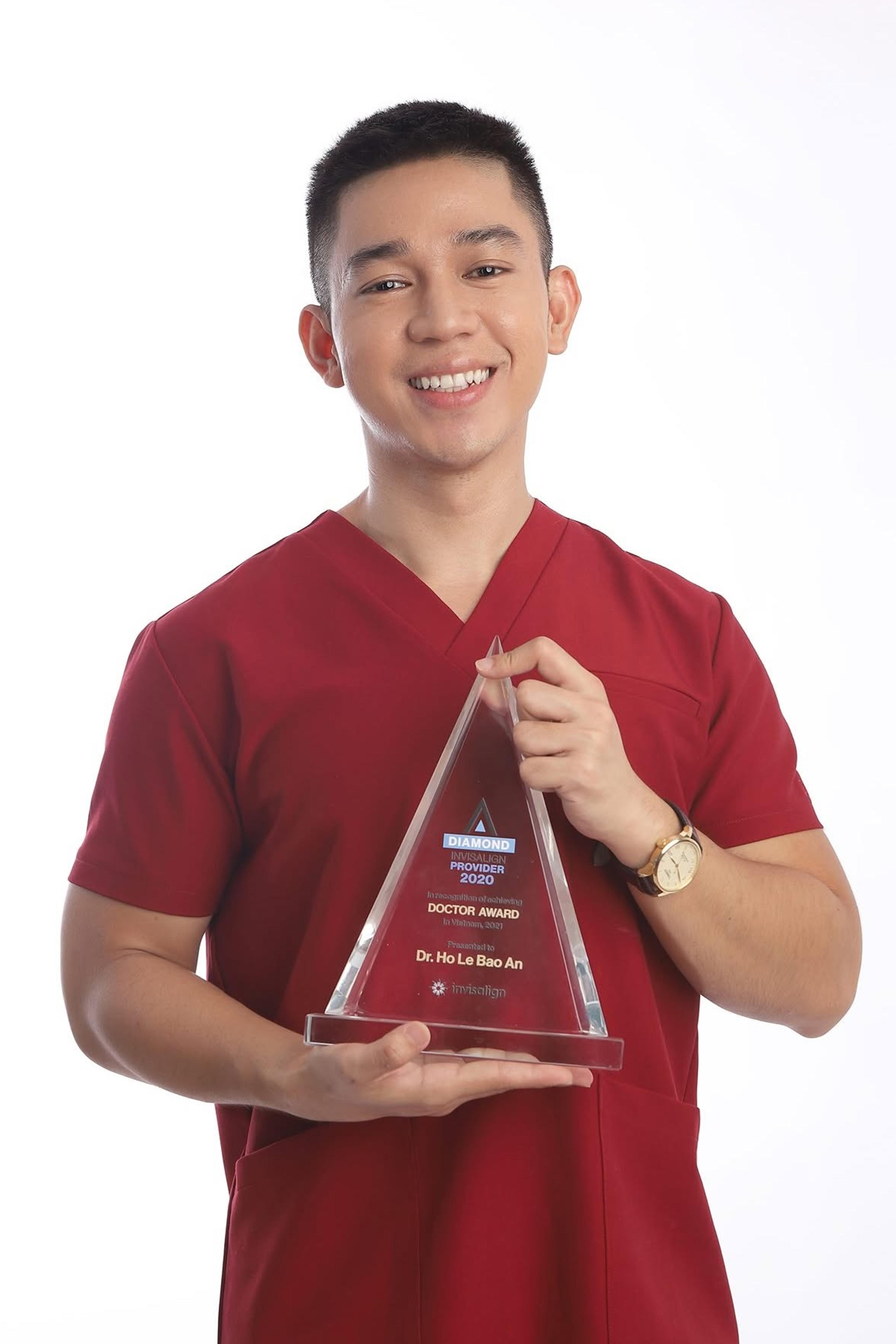 Dr Ho Le Bao An holding the Invisalign Diamond Provider glass trophy, engraved Doctor Award in Vietnam, 2021
