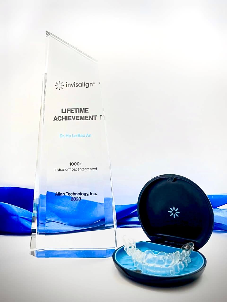 The Invisalign Lifetime Achievement trophy awarded to Dr Ho Le Bao An, Align Technology 2023, beside a clear aligner case