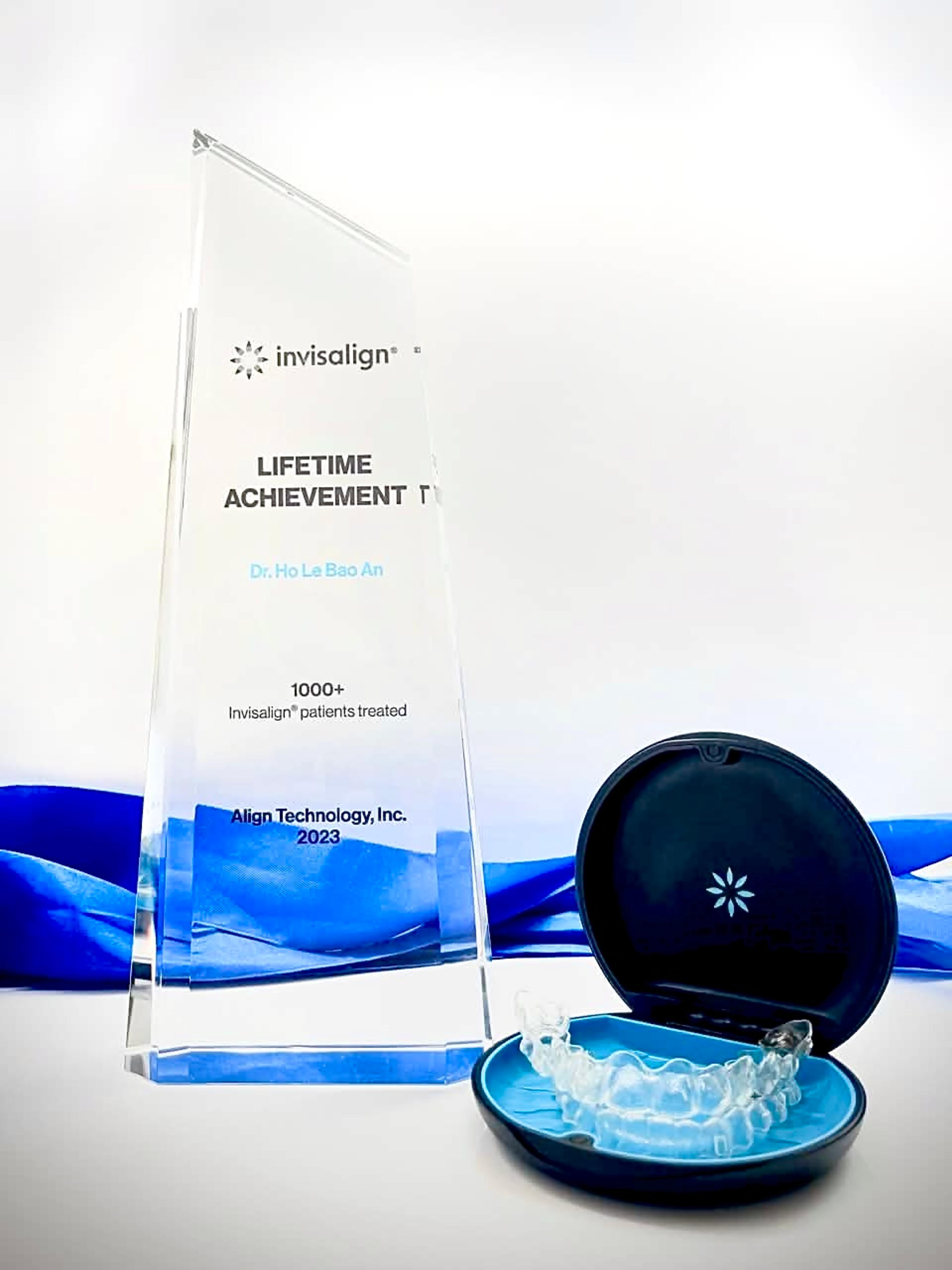 The Invisalign Lifetime Achievement trophy awarded to Dr Ho Le Bao An, Align Technology 2023, beside a clear aligner case